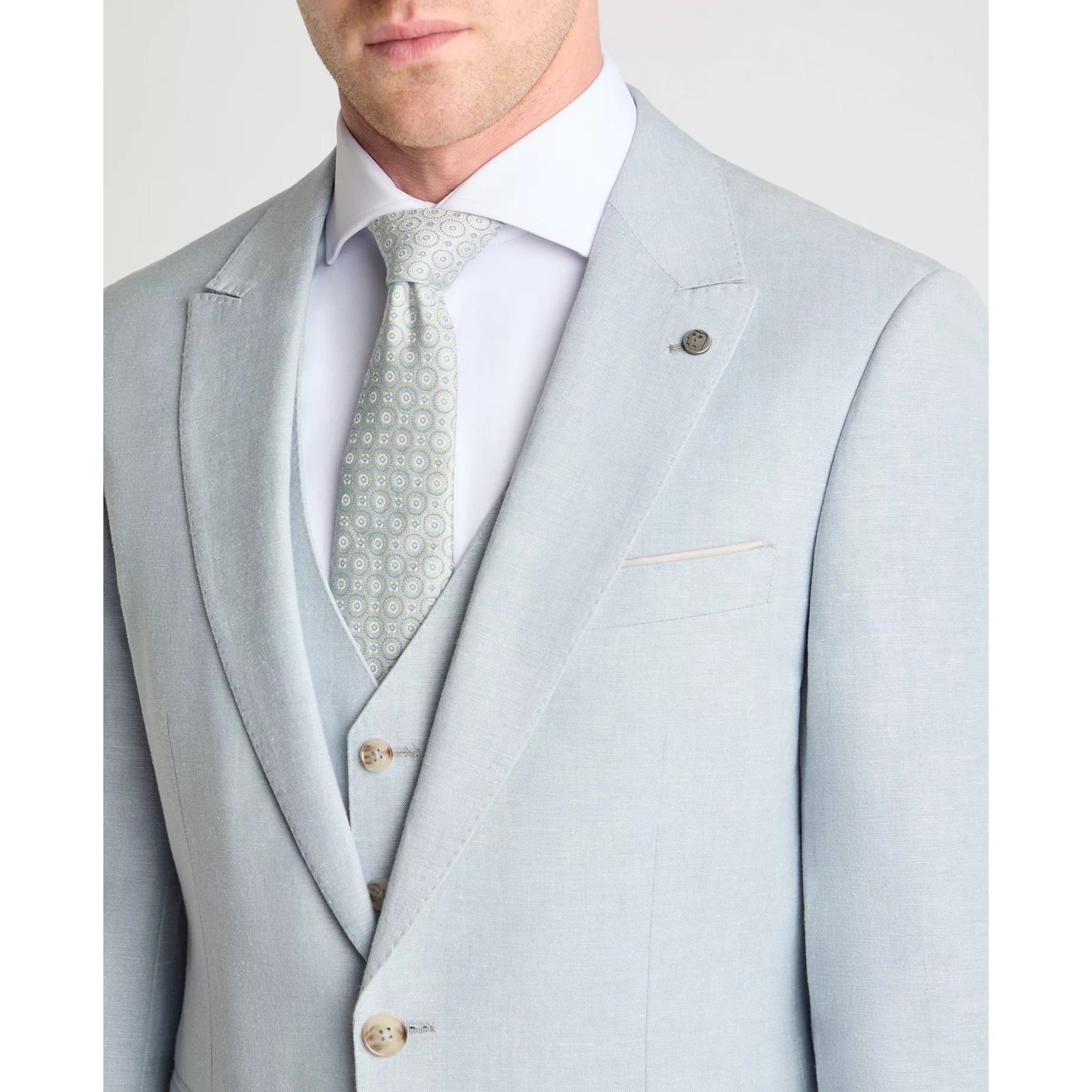 sky blue suit with a patterned tie on a plain background