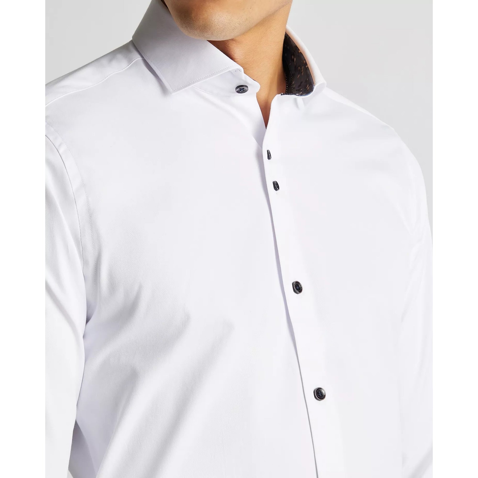 White dress shirt with black buttons on a white background