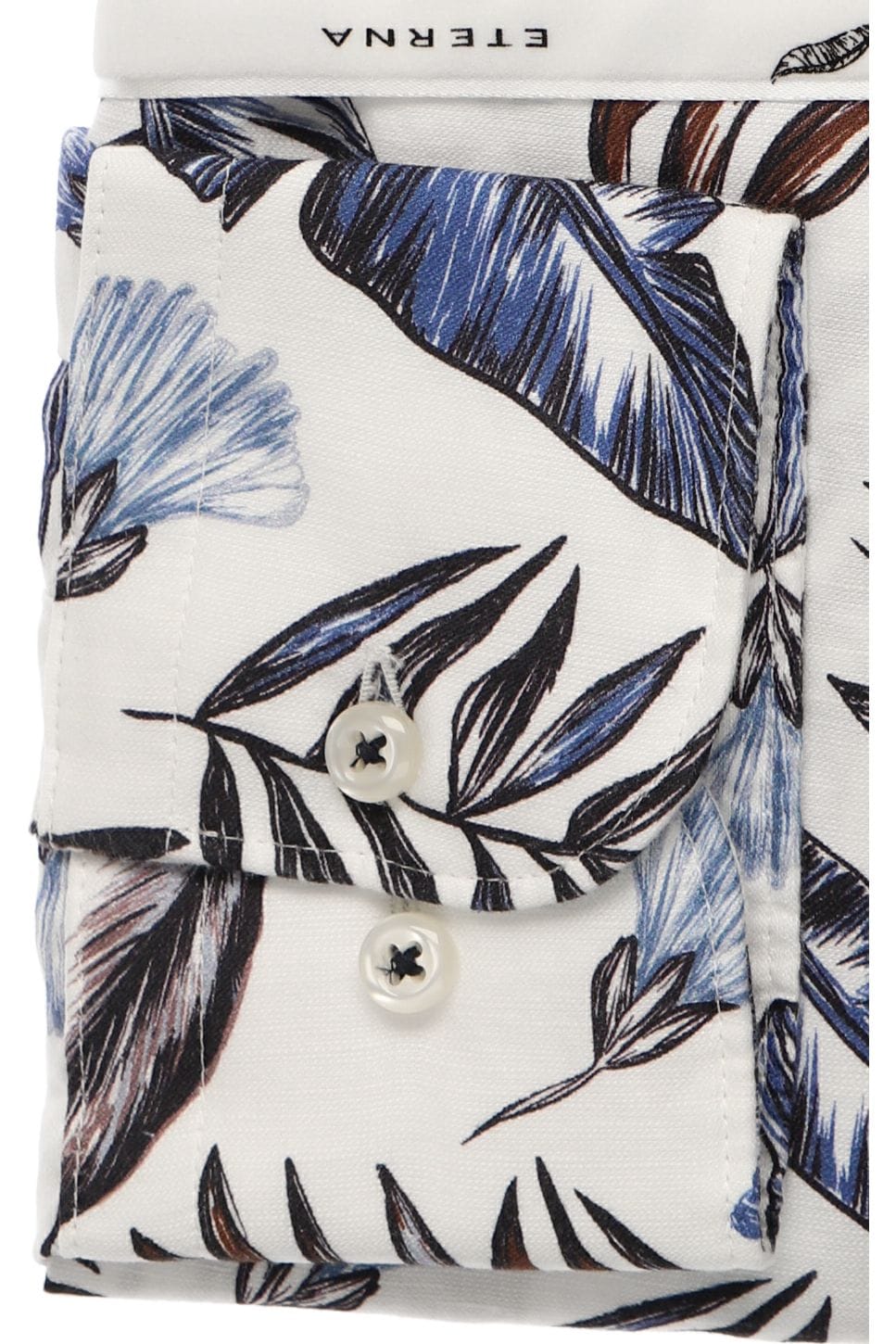 Cuff of shirt with blue and black leaf pattern on a white background