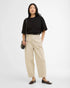 Woman wearing a black t-shirt and beige pants on a white background
