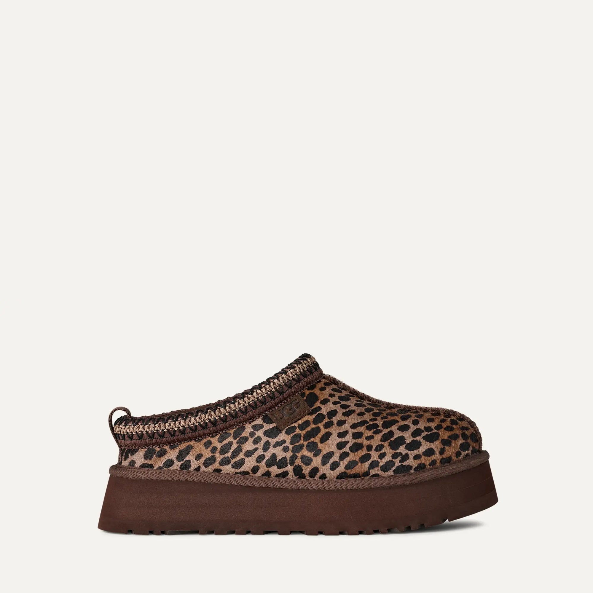 Leopard print slip-on shoe with brown sole on a white background
