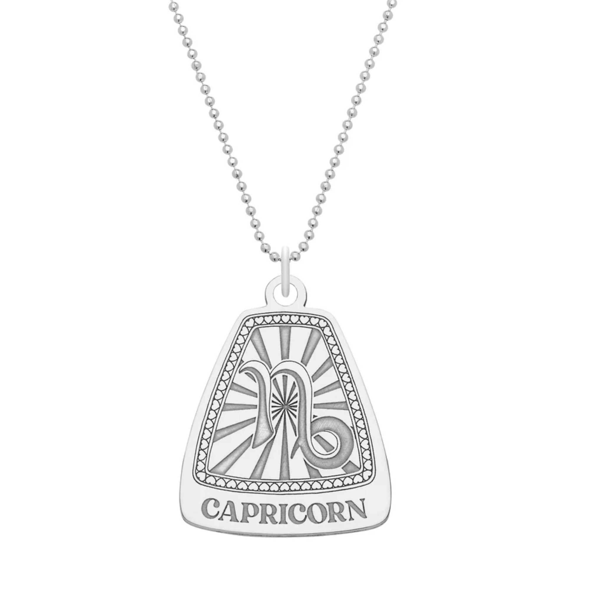 A silver pendant necklace with a hand-drawn Capricorn zodiac sign design, featuring a curb chain.
