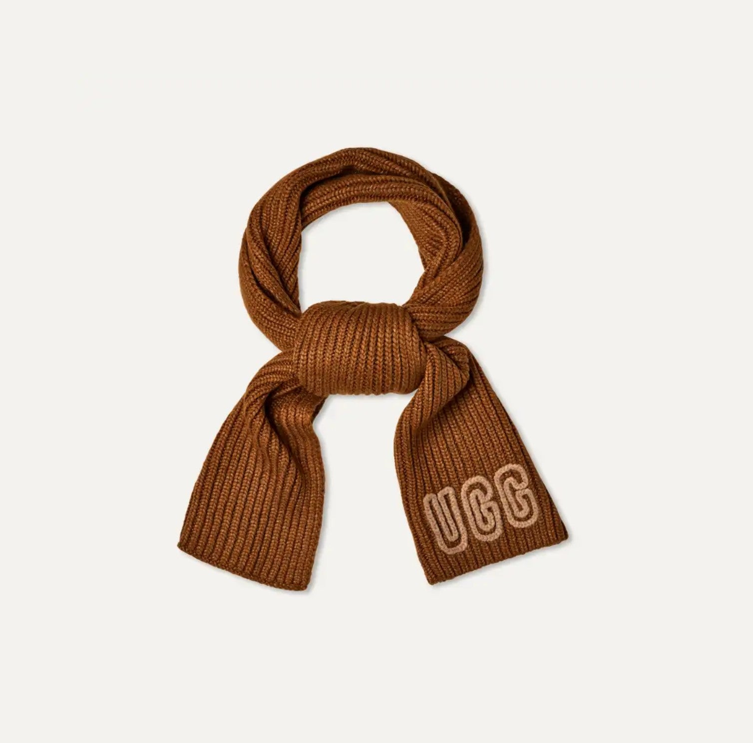 Brown knit scarf with 'UGG' logo on a light beige background