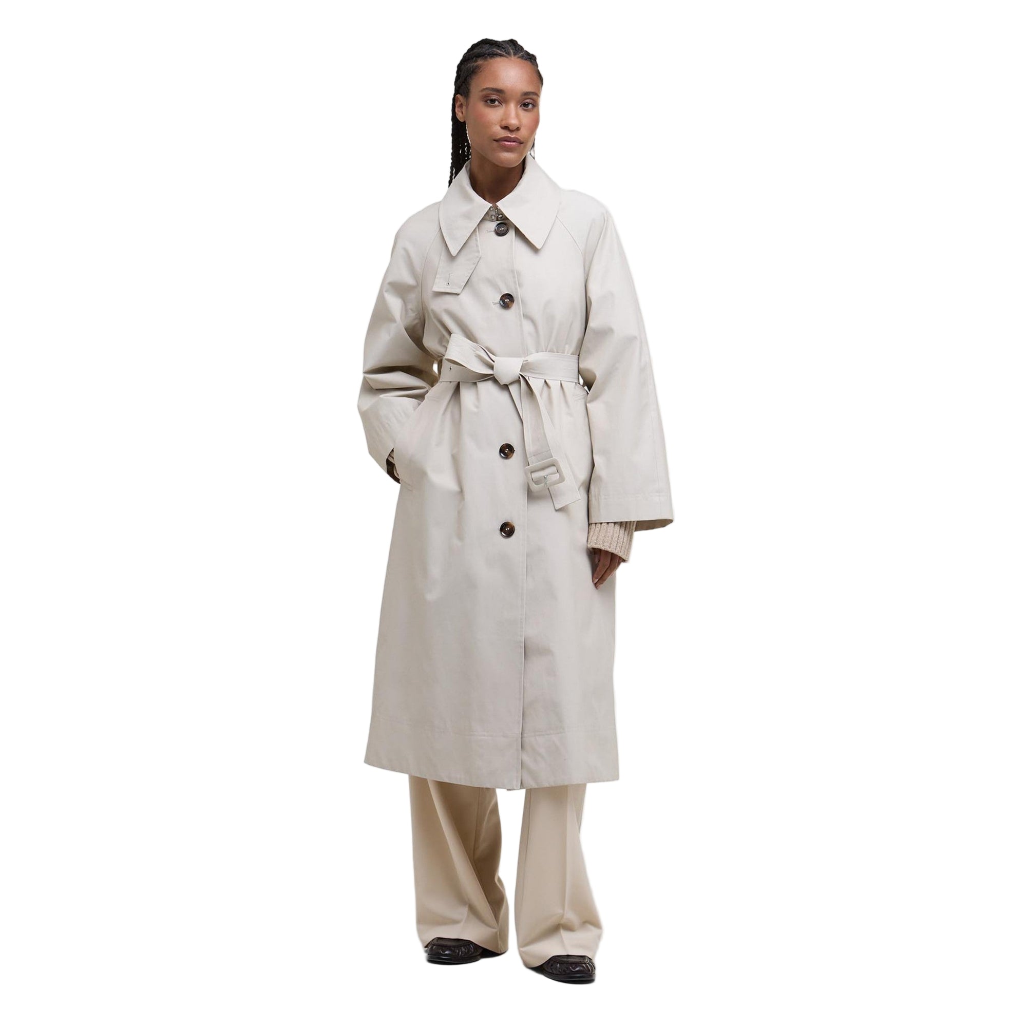 Person wearing a beige trench coat on a white background