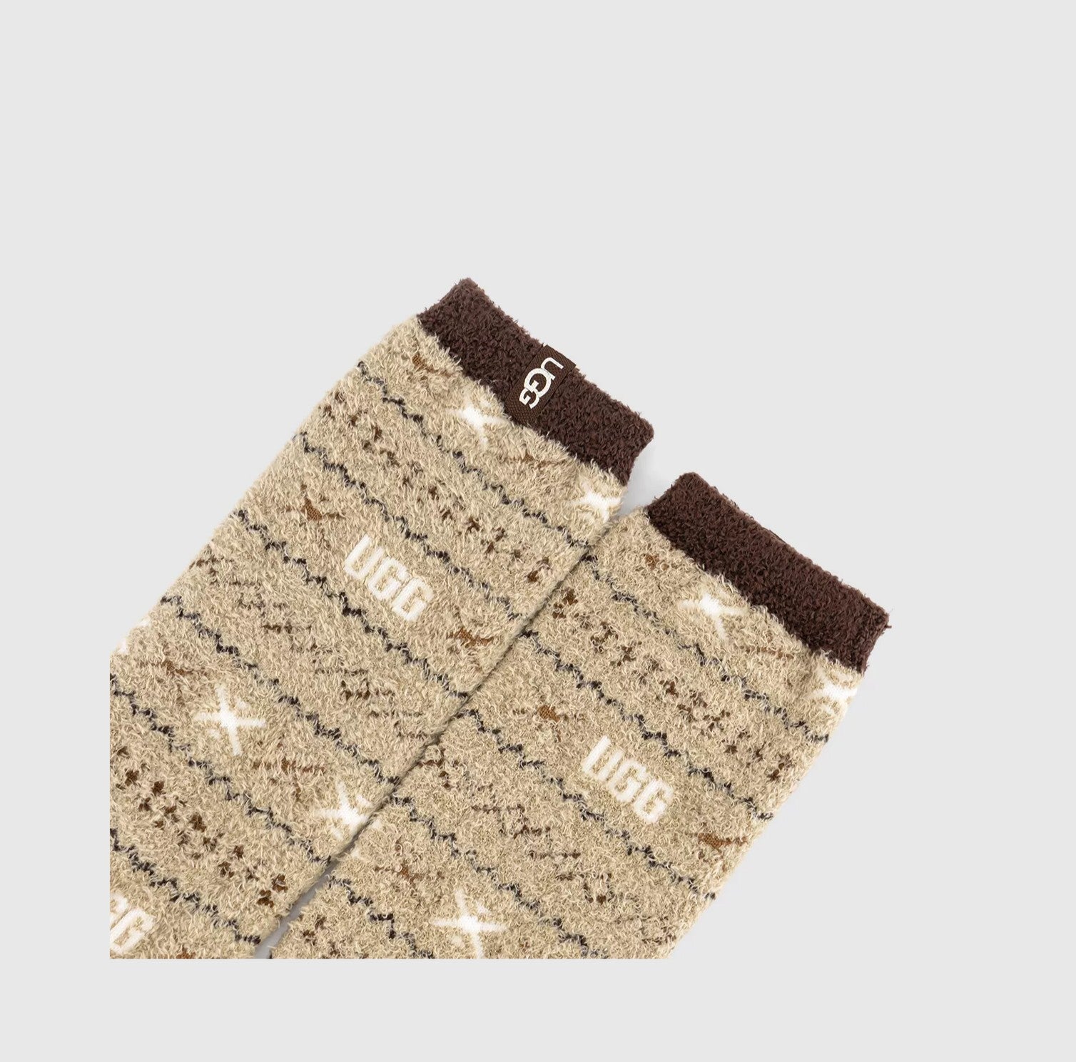 Pair of beige and brown patterned socks with 'UGG' branding on a light gray background