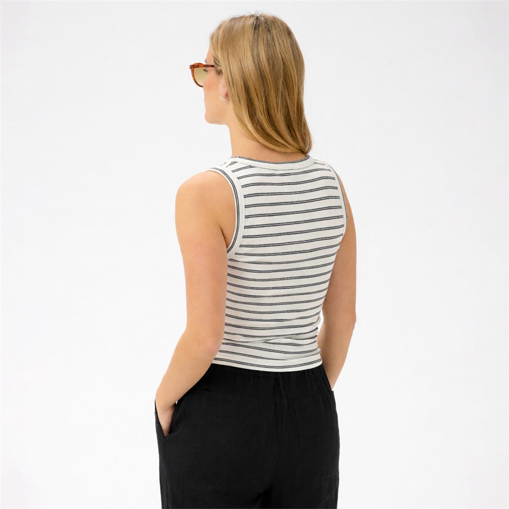 Woman wearing a striped tank top and black pants on a white background