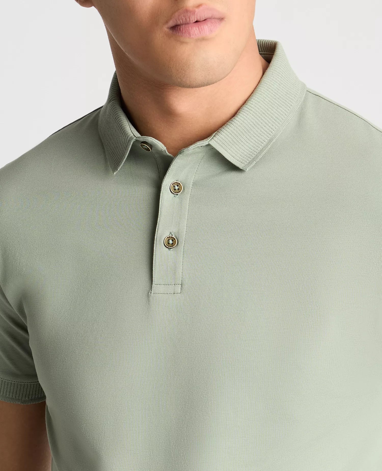 Light green polo shirt worn by a person on a plain background
