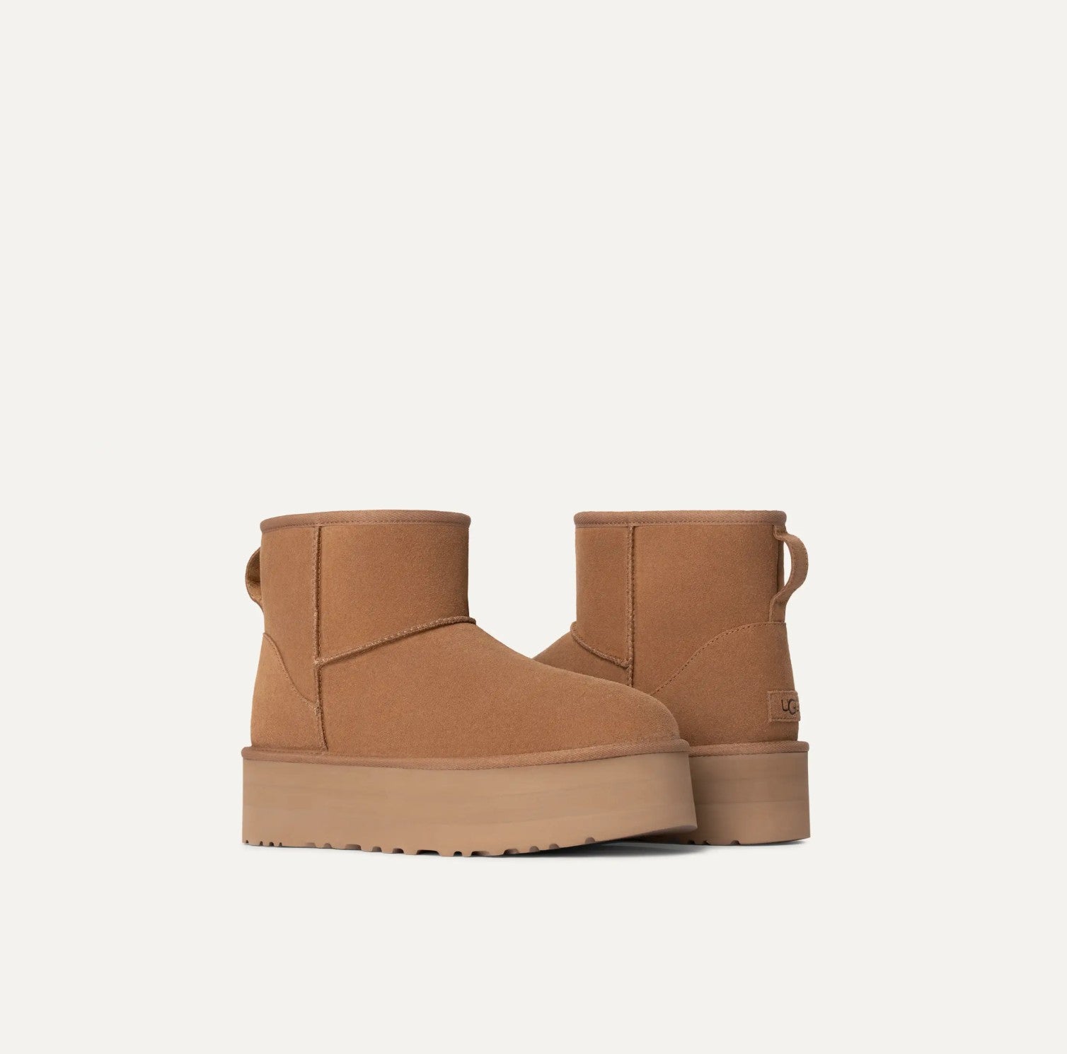 Pair of tan platform boots on a white background