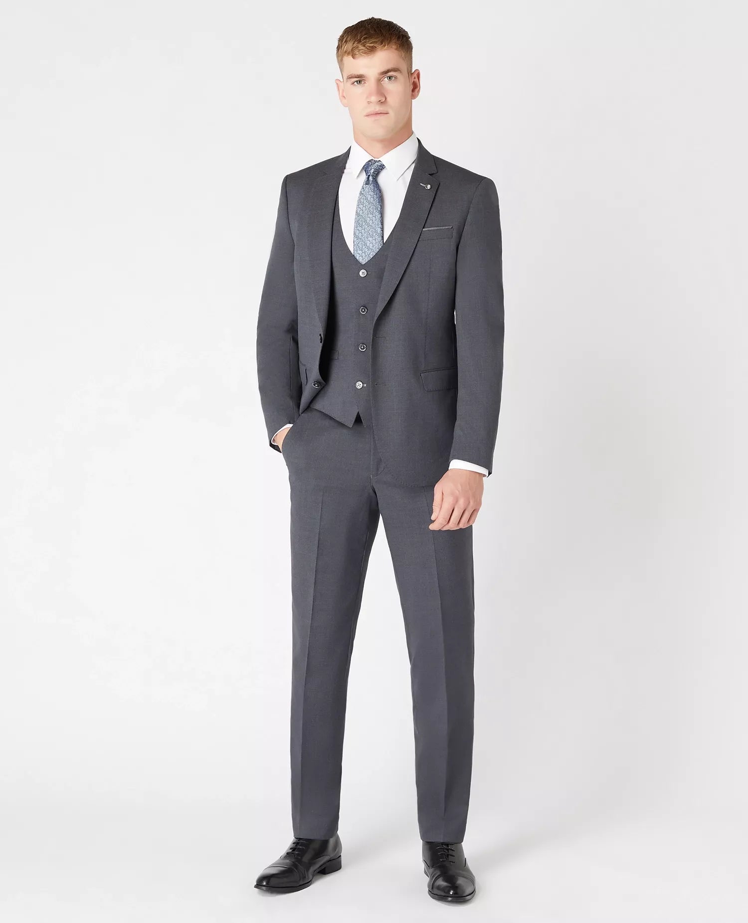 Man wearing a gray suit with a white shirt and blue tie on a white background