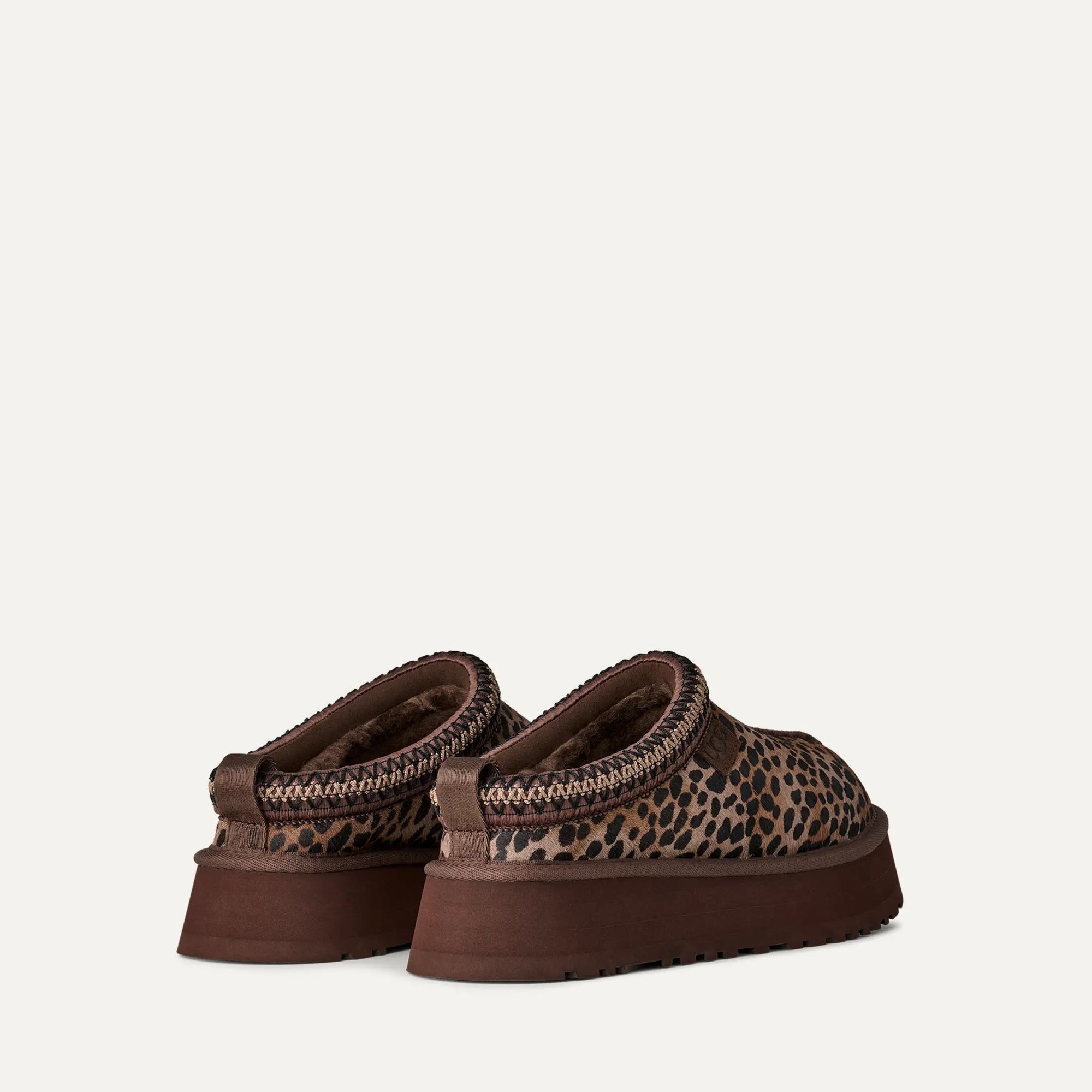 Pair of brown loafers with leopard print pattern on a white background