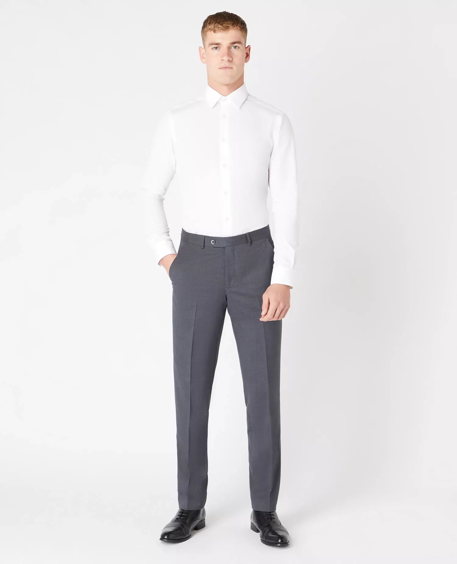 Man wearing a white dress shirt and gray pants on a white background