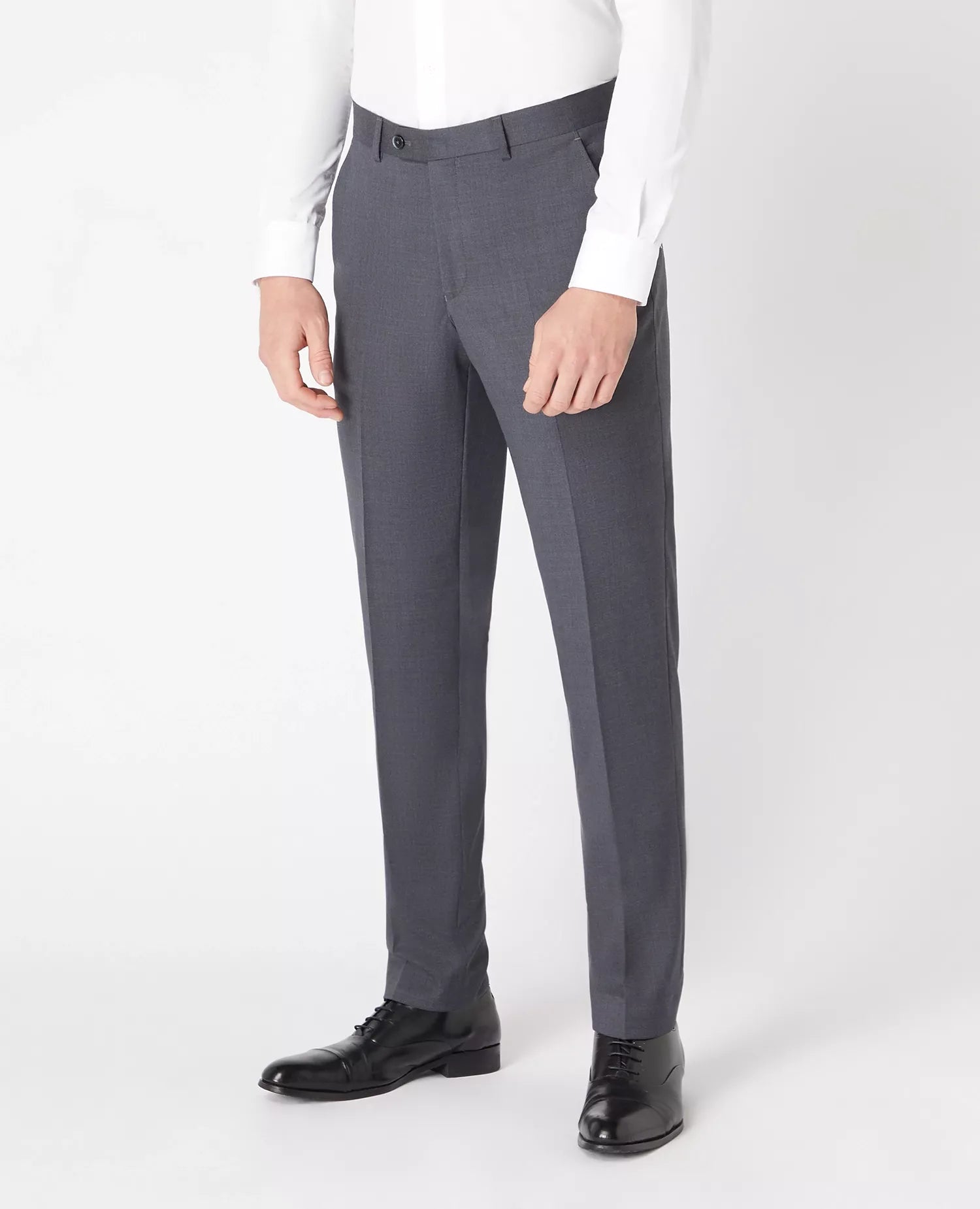 Gray dress pants worn with a white shirt and black shoes on a white background