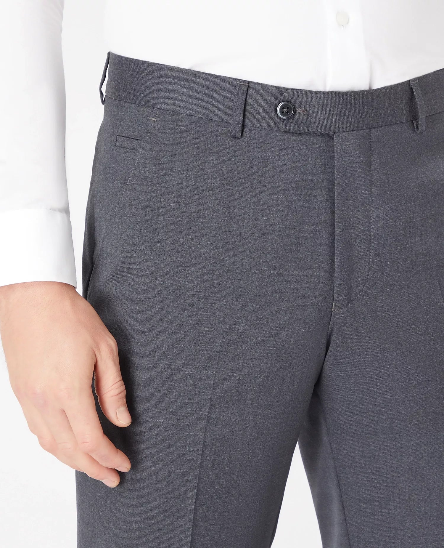 Gray suit pants with a white shirt and hand visible