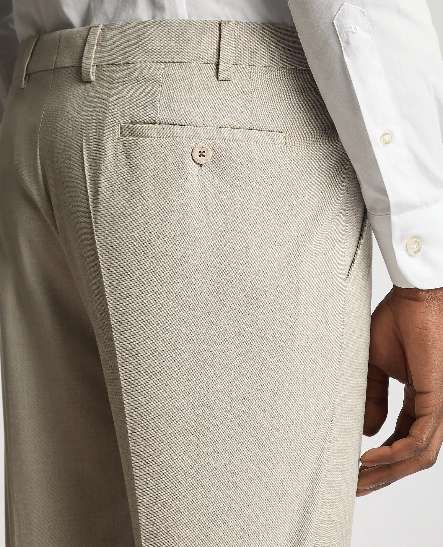 Beige dress pants with a white shirt on a light gray background