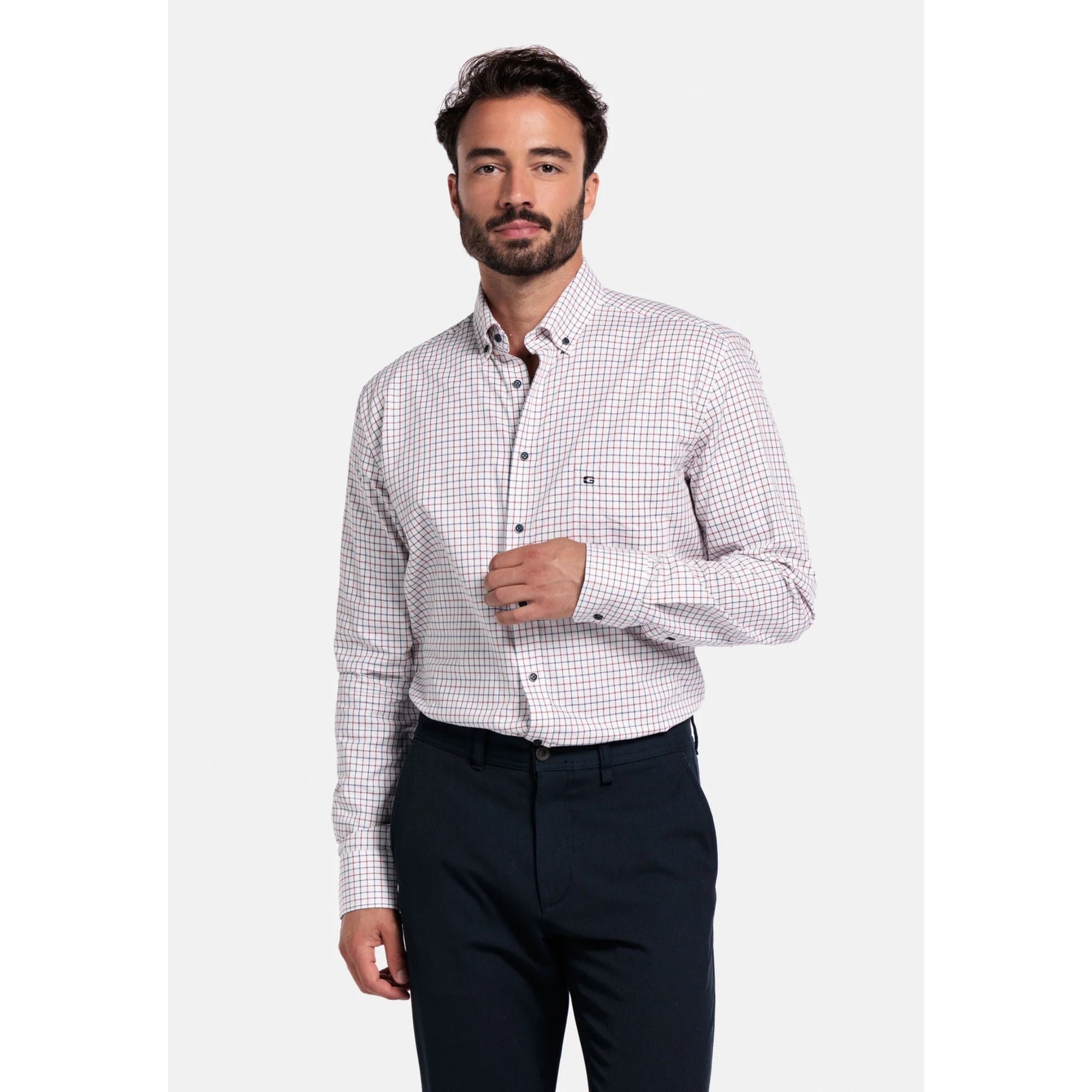 Man wearing a checkered Giordano shirt and dark pants on a white background