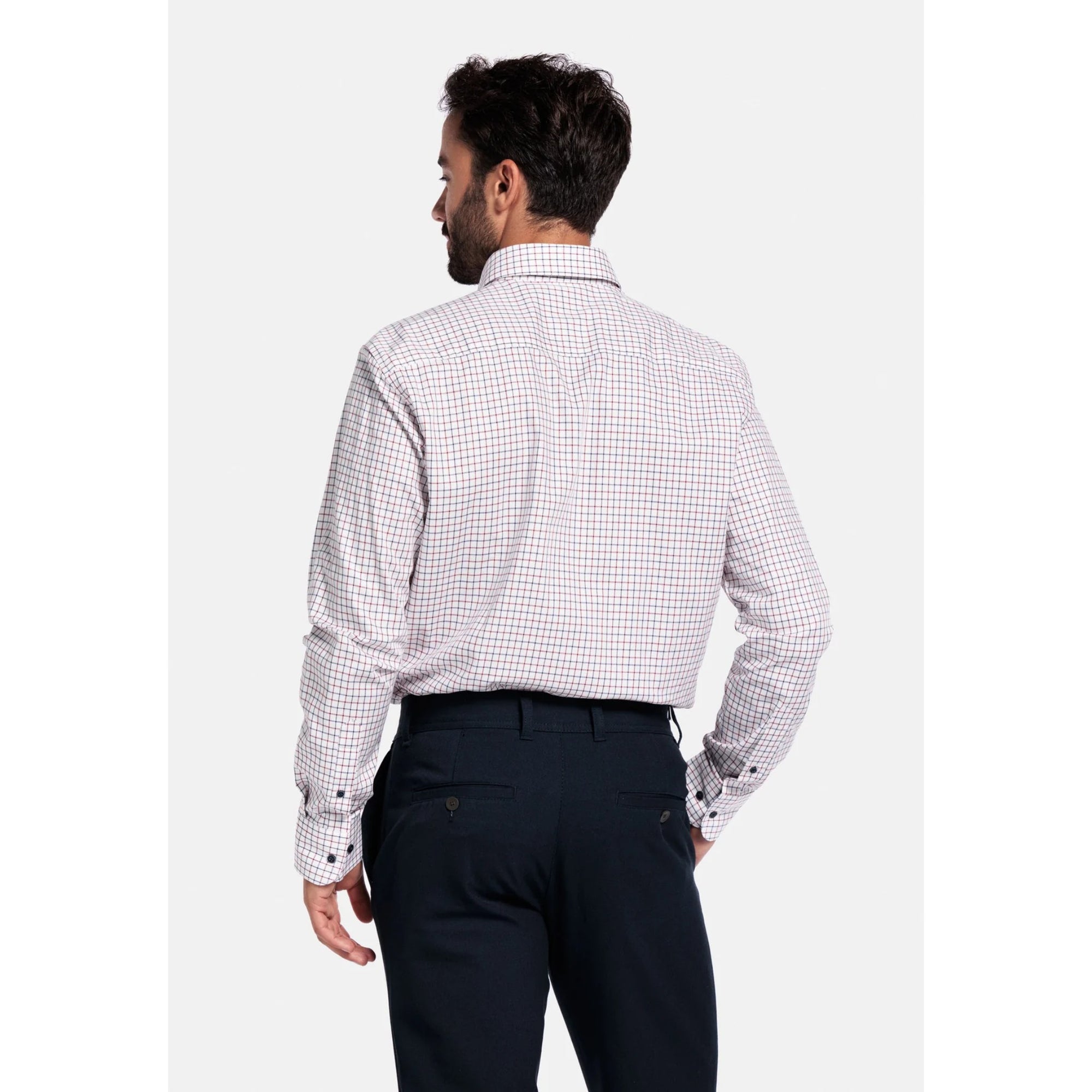 Man wearing a checkered Giordano shirt and dark pants on a white background