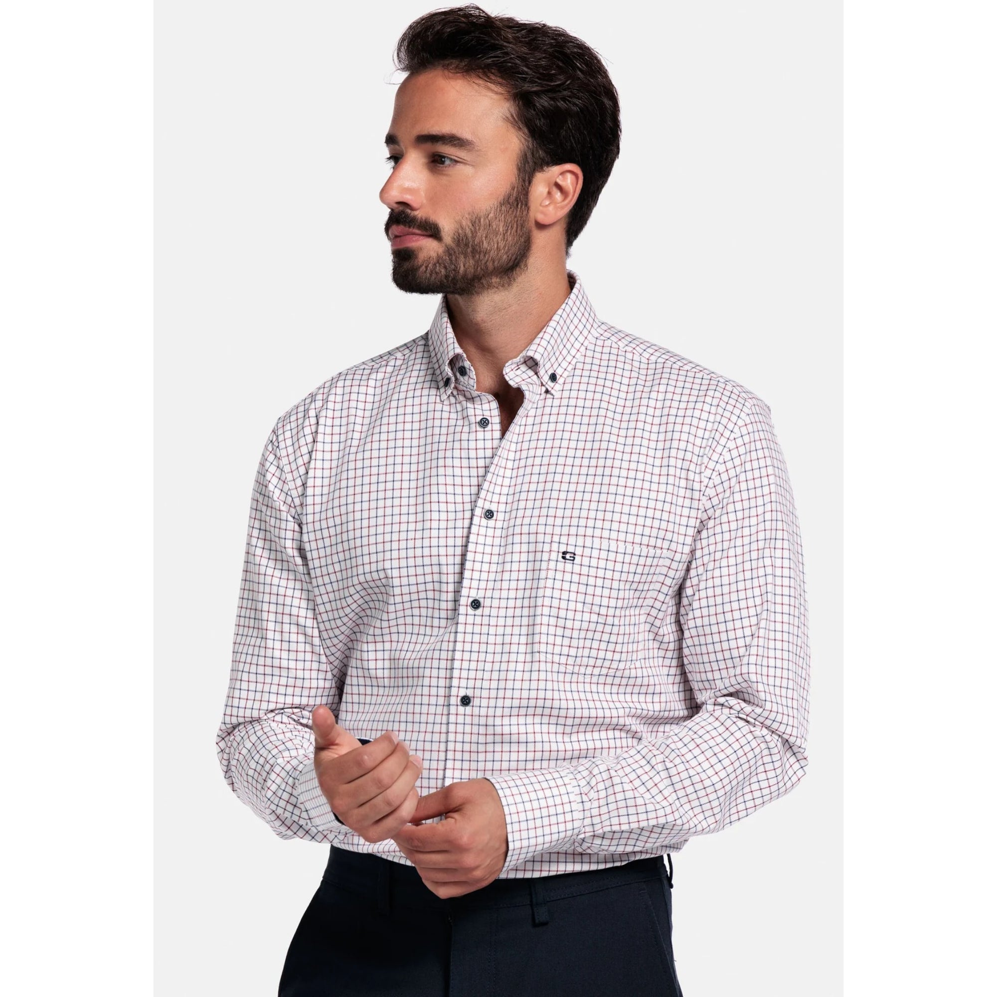 Man wearing a checkered Giordano shirt and dark pants on a white background