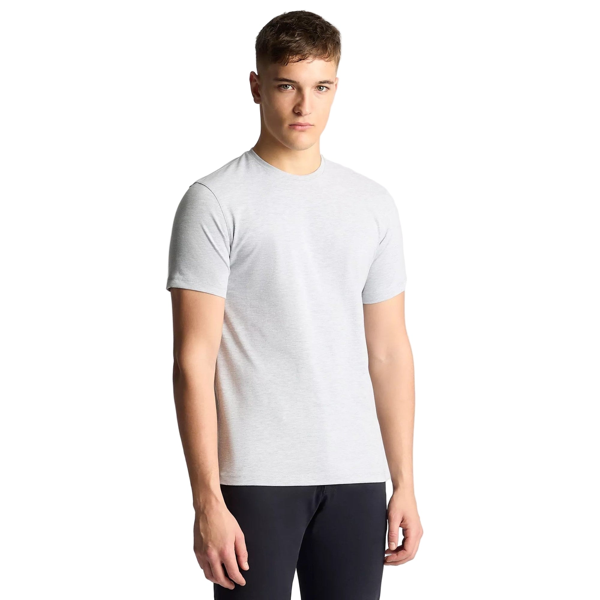 Man wearing a plain white t-shirt against a light gray background