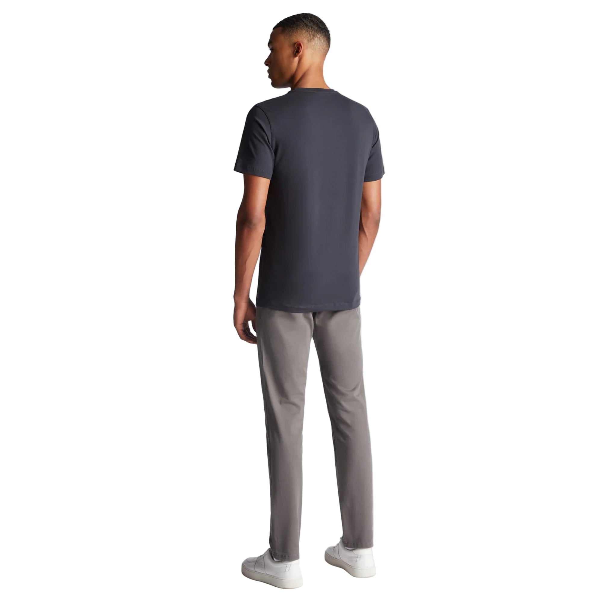 Man wearing a dark gray t-shirt and light gray pants on a white background