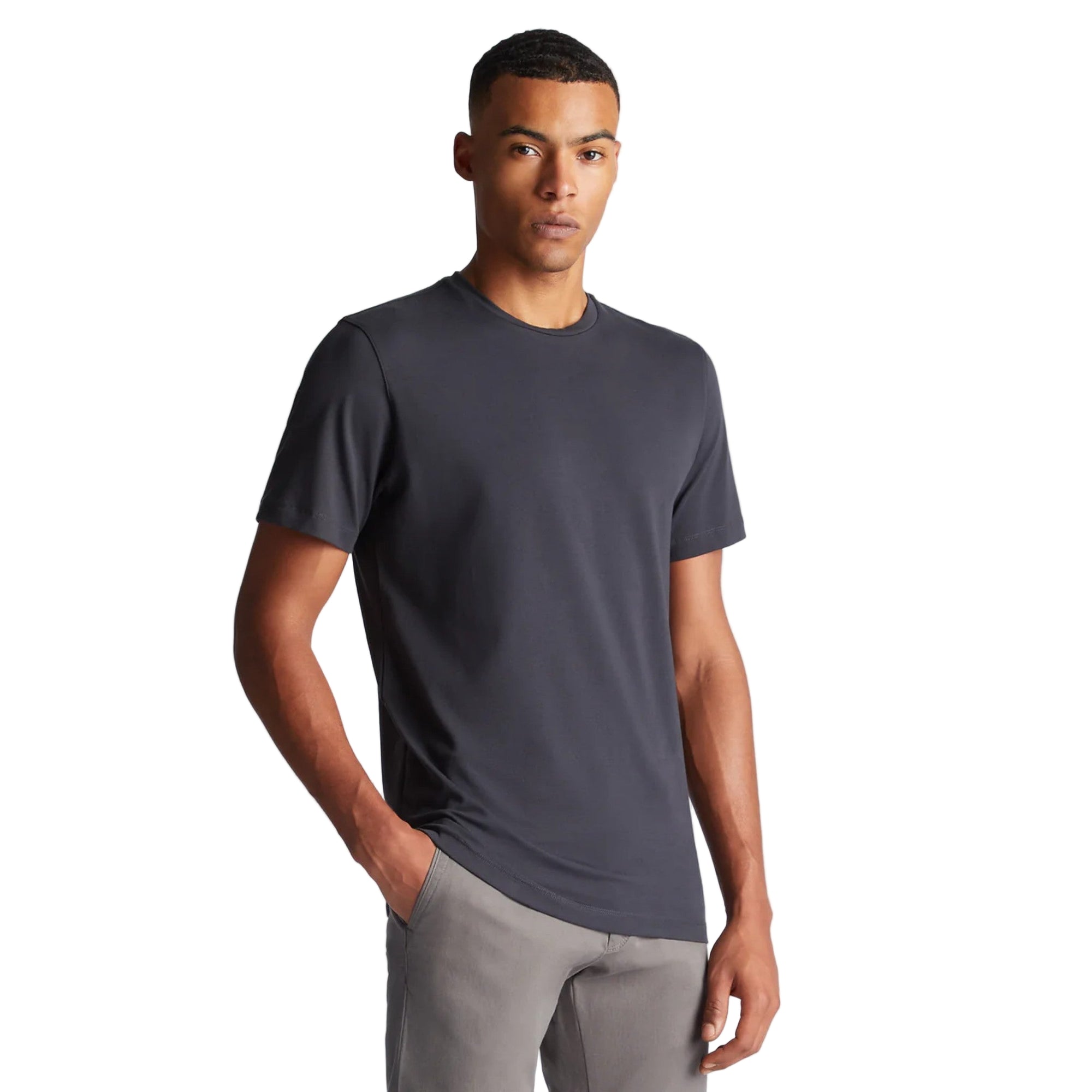 Man wearing a dark gray t-shirt and light gray pants on a white background