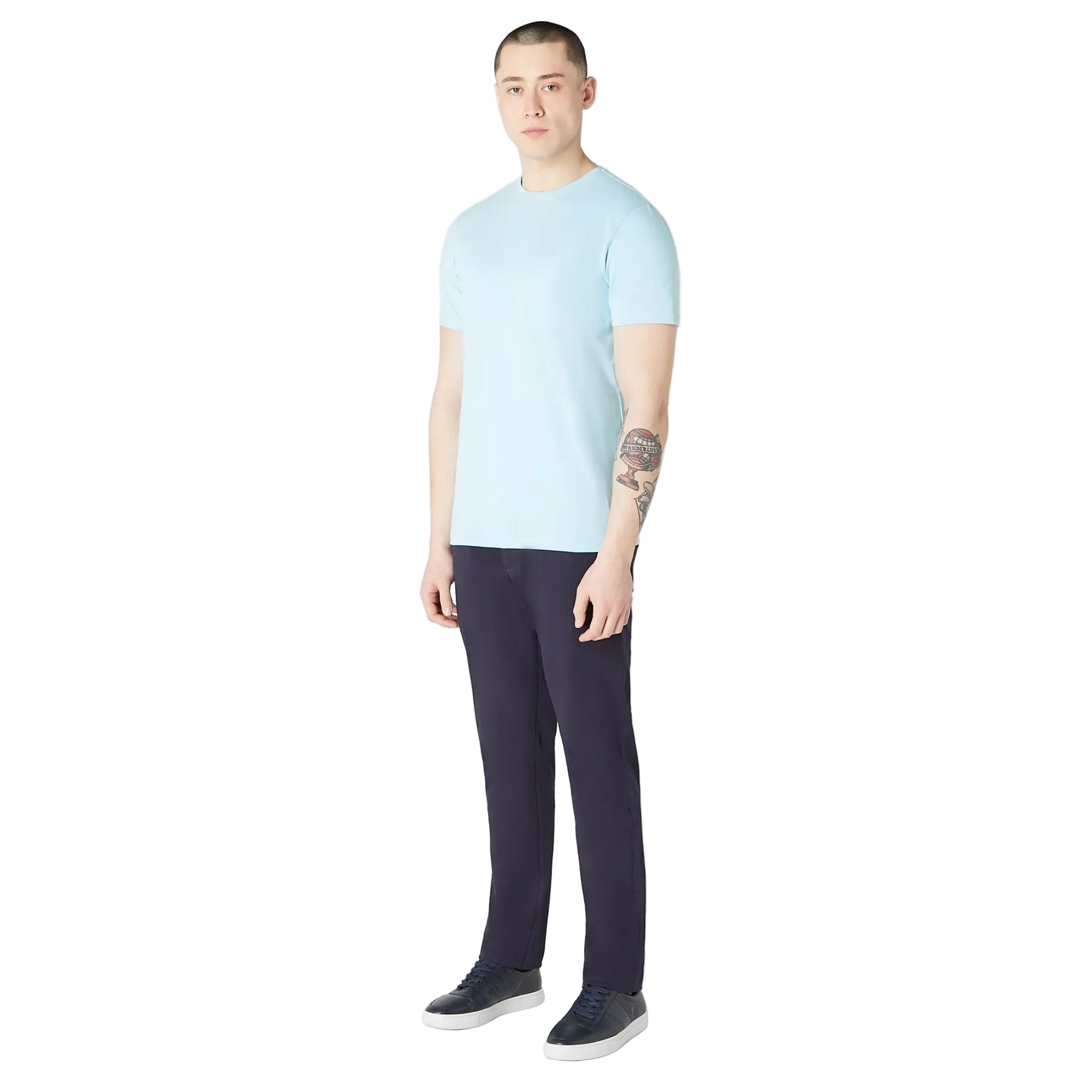 Man wearing a light blue t-shirt and dark pants on a white background