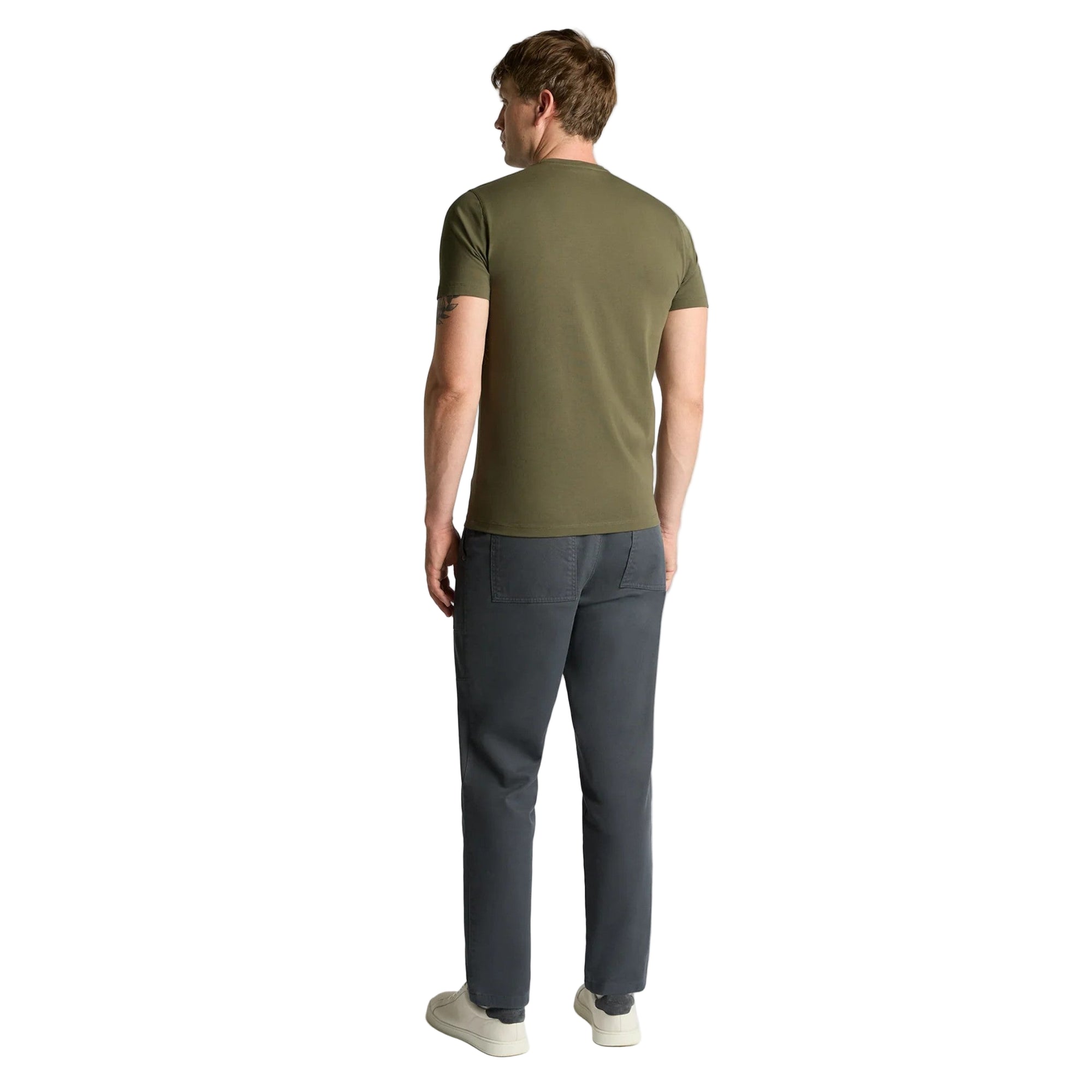 Man wearing a green t-shirt and gray pants on a white background