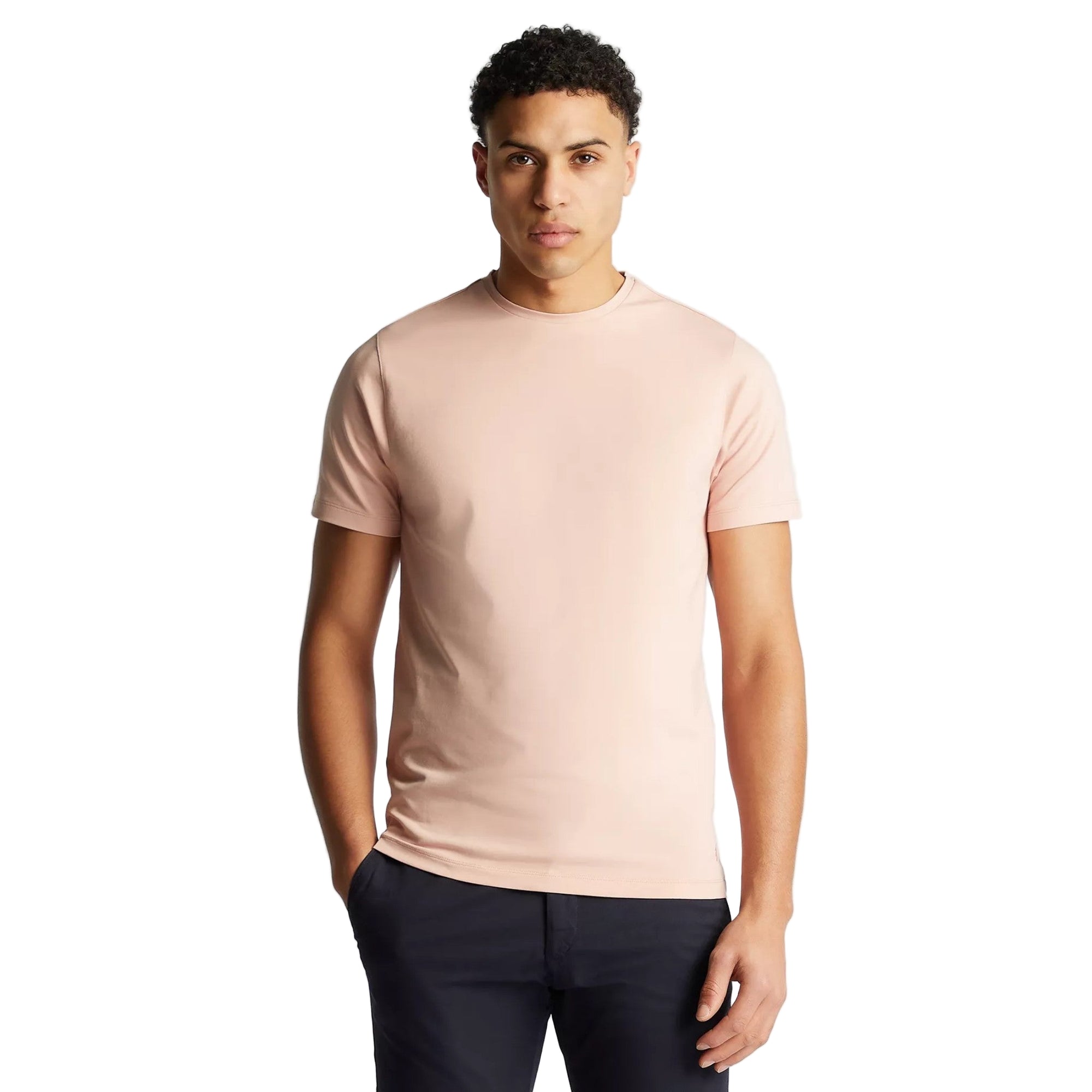 Man wearing a light pink t-shirt against a plain background
