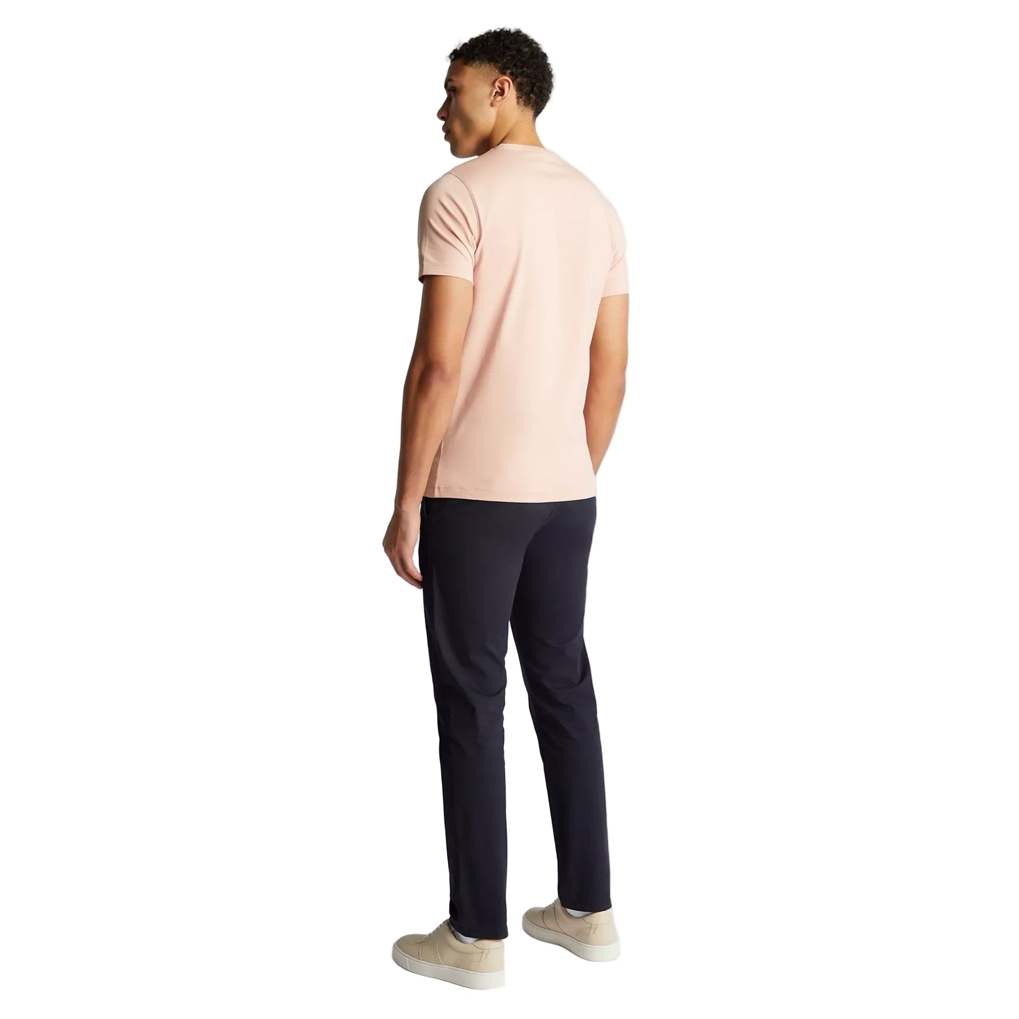 Person wearing a light pink t-shirt and black pants on a white background