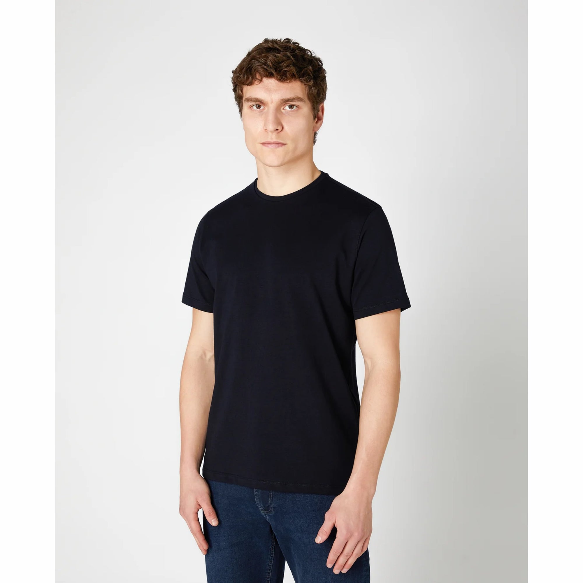Man wearing a navy t-shirt and blue jeans