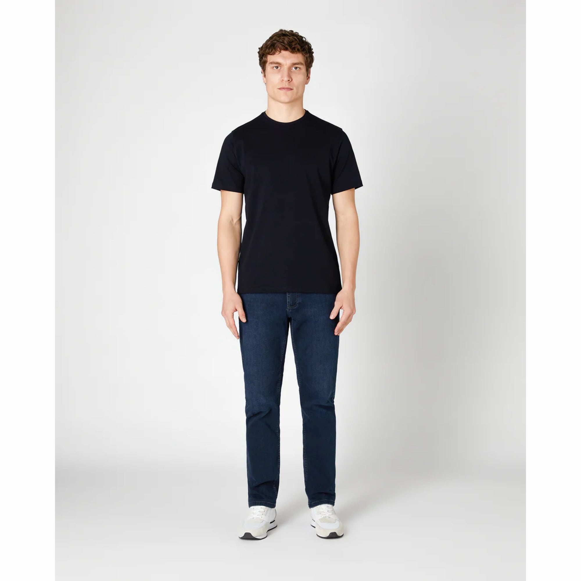 Man wearing a navy t-shirt and blue jeans