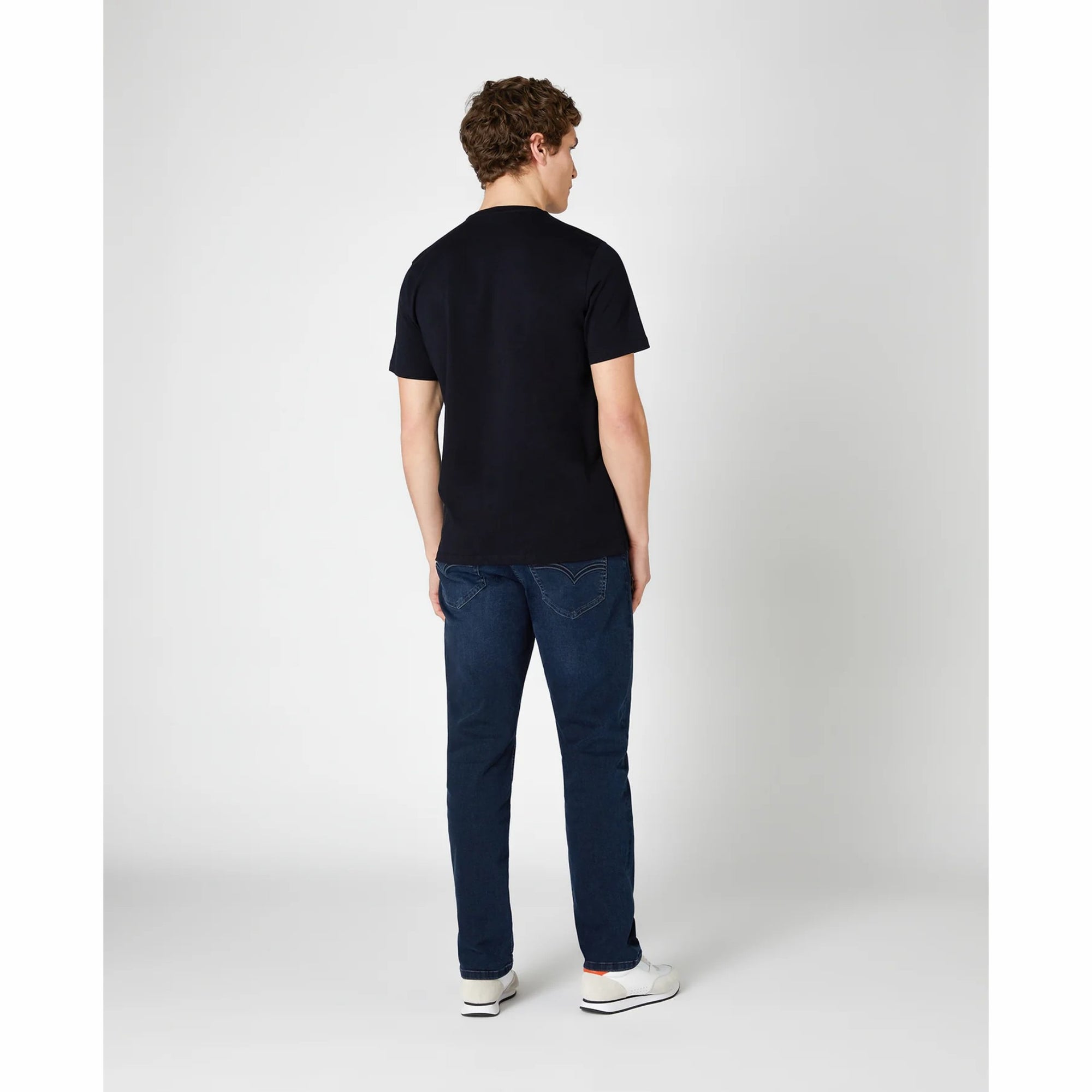 Man wearing a navy t-shirt and blue jeans