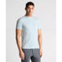 Man wearing a light blue t-shirt and gray pants on a white background