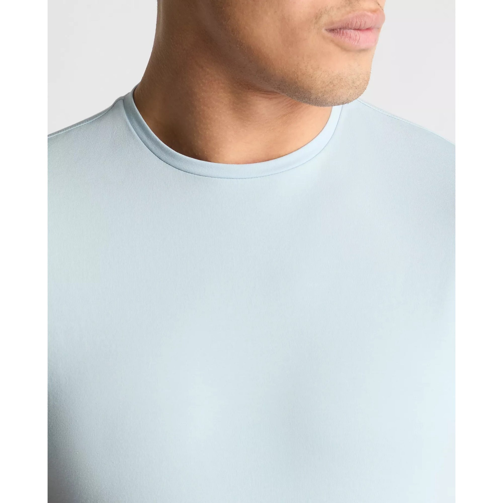 Light blue t-shirt worn by a person on a plain background