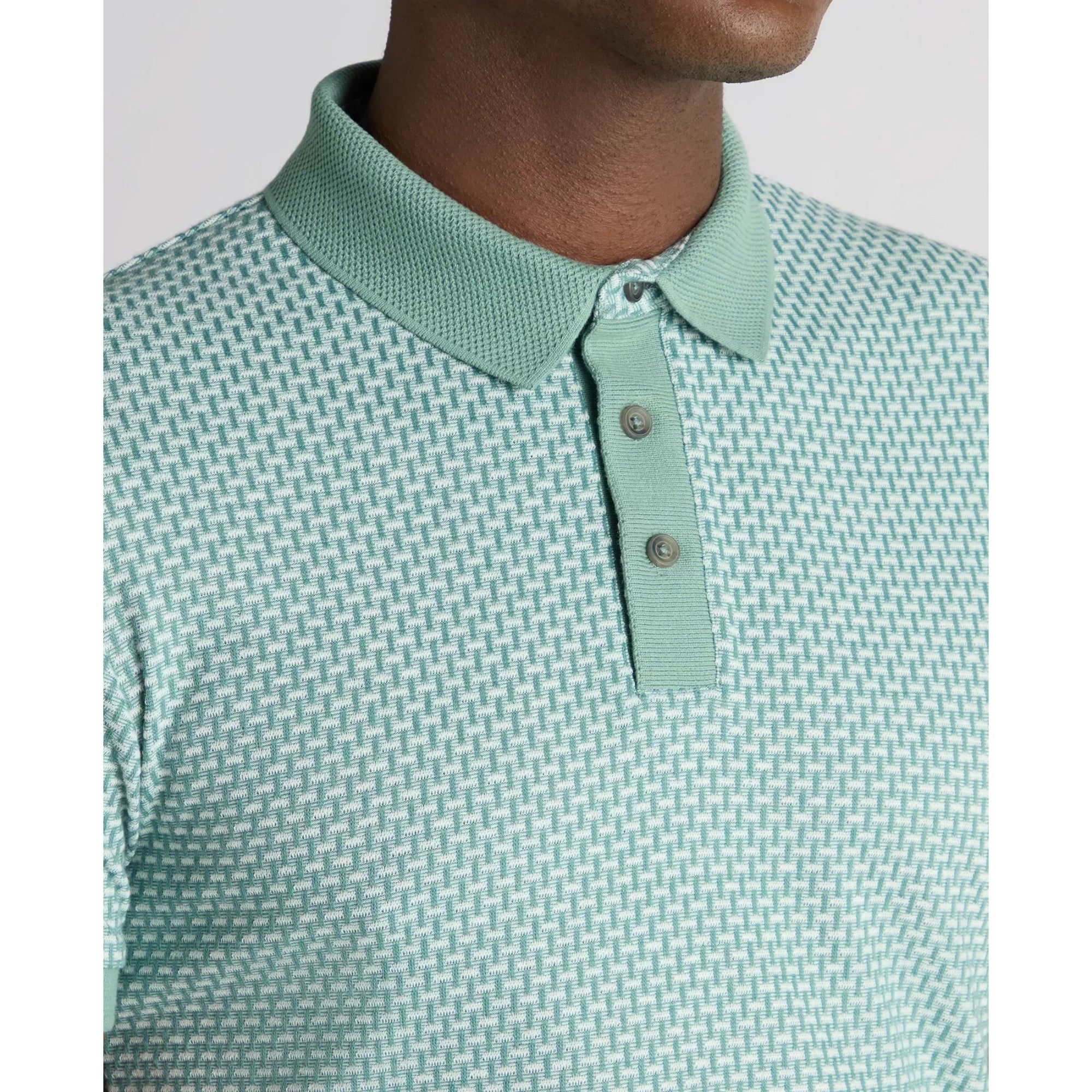 Green patterned polo shirt with collar and buttons on a plain background