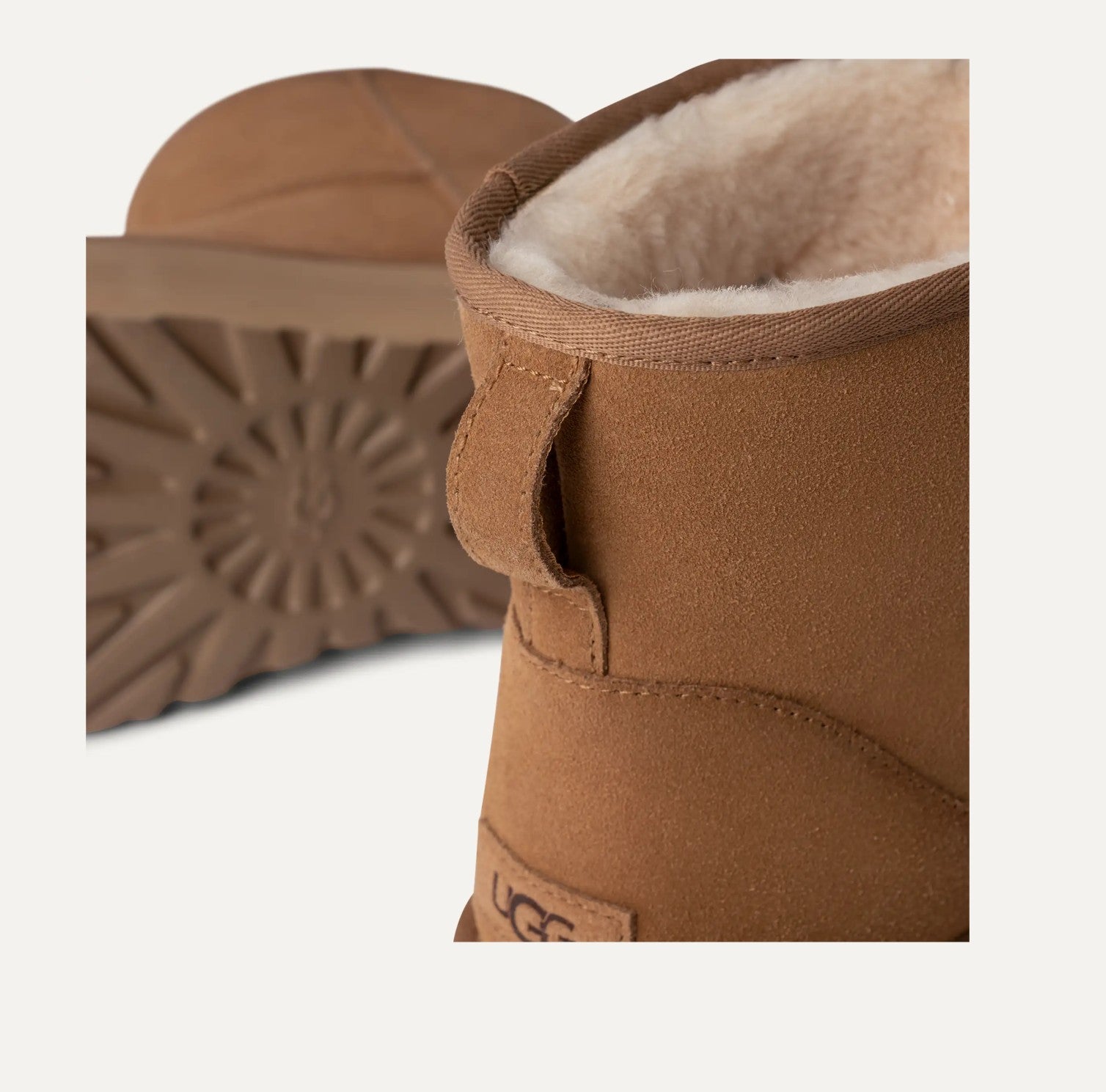 Close-up of a brown UGG boot with visible branding on a white background