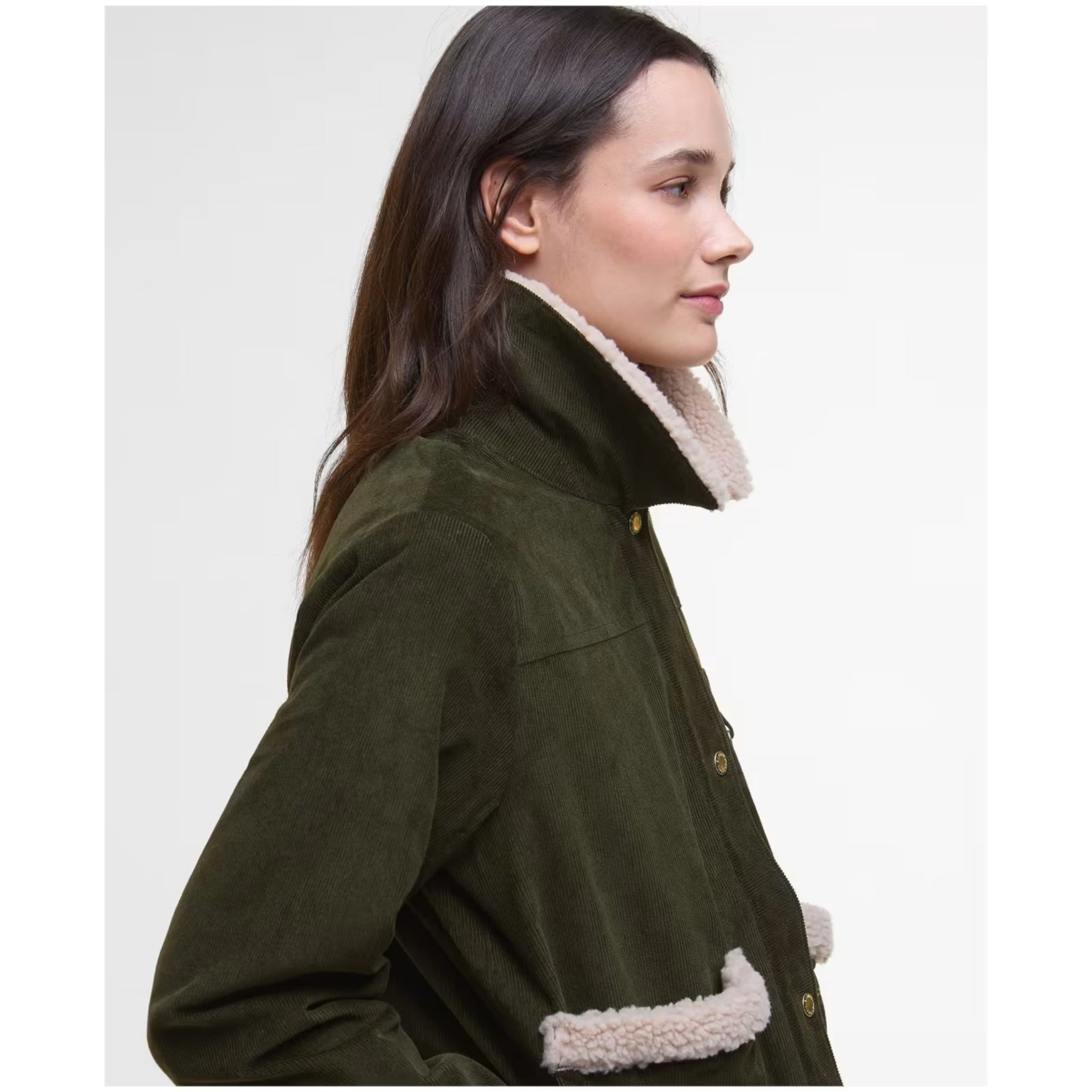 Woman wearing a green coat with white fur trim on a plain background