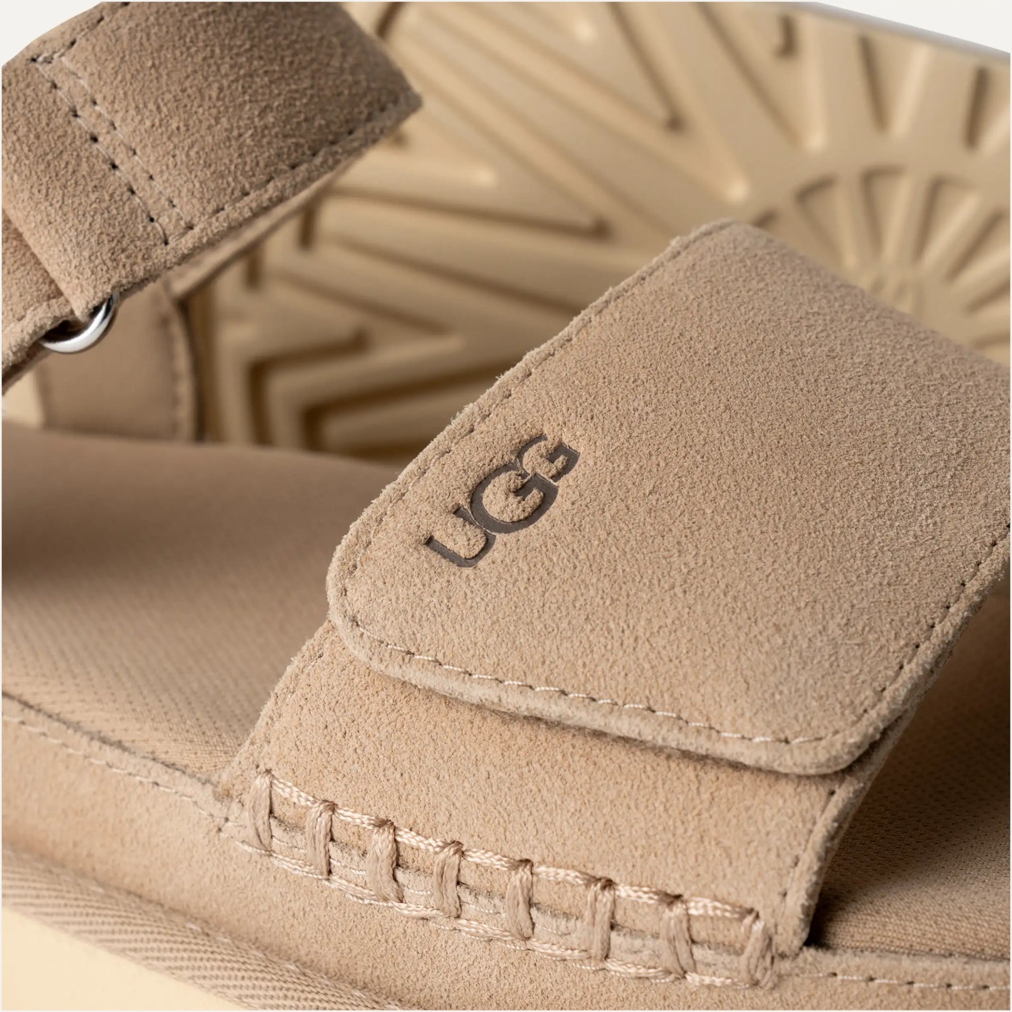 A beige Ugg Goldenstar sandal with an adjustable ankle strap and hook-and-loop closure.