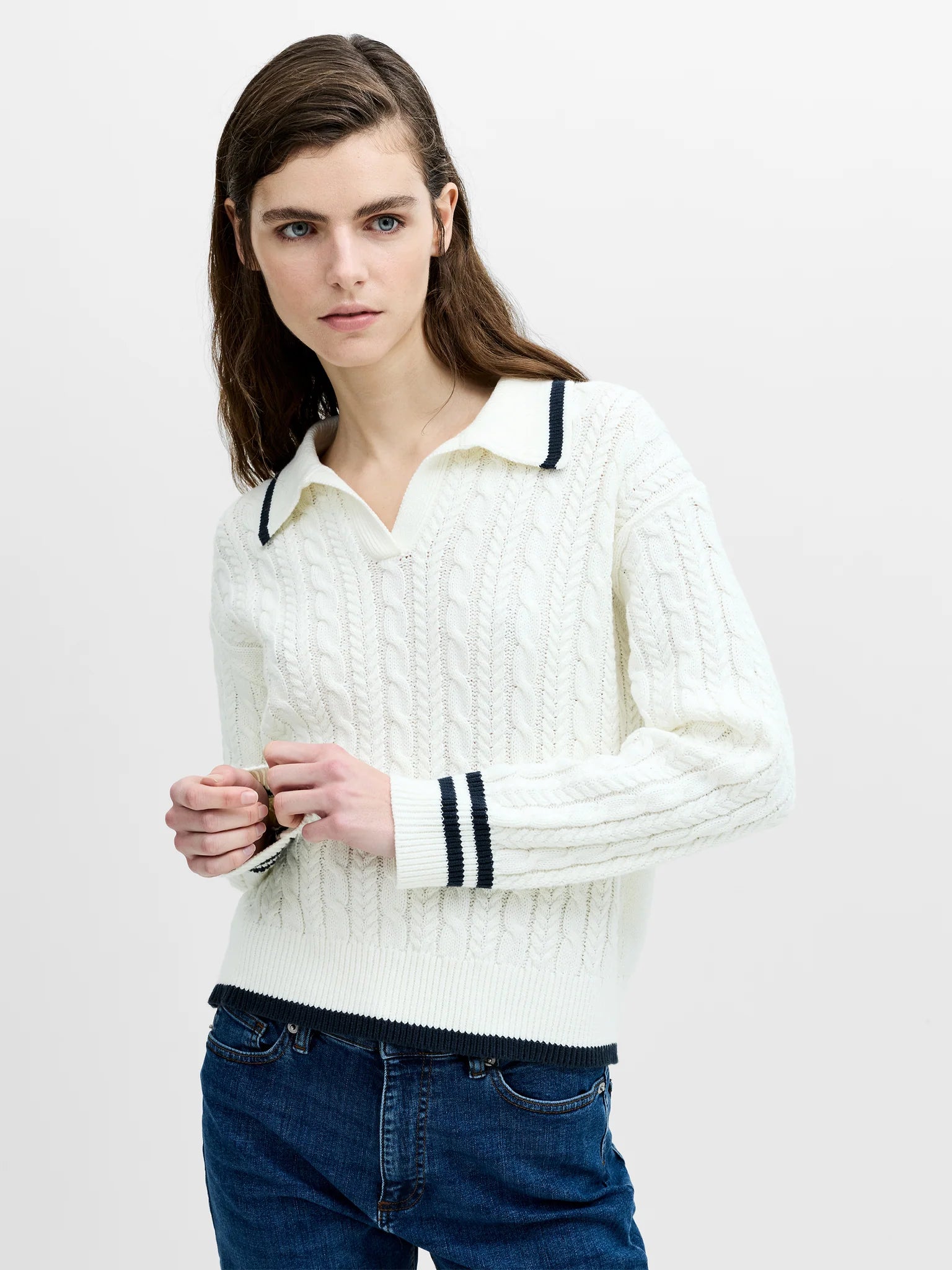 Woman wearing a French Connection Klara White cable knit polo jumper with navy trim.