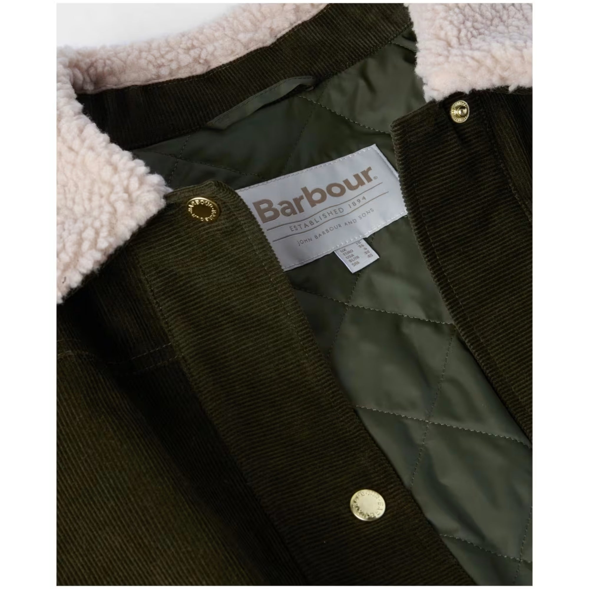Close-up of a Barbour jacket with a label and quilted texture.