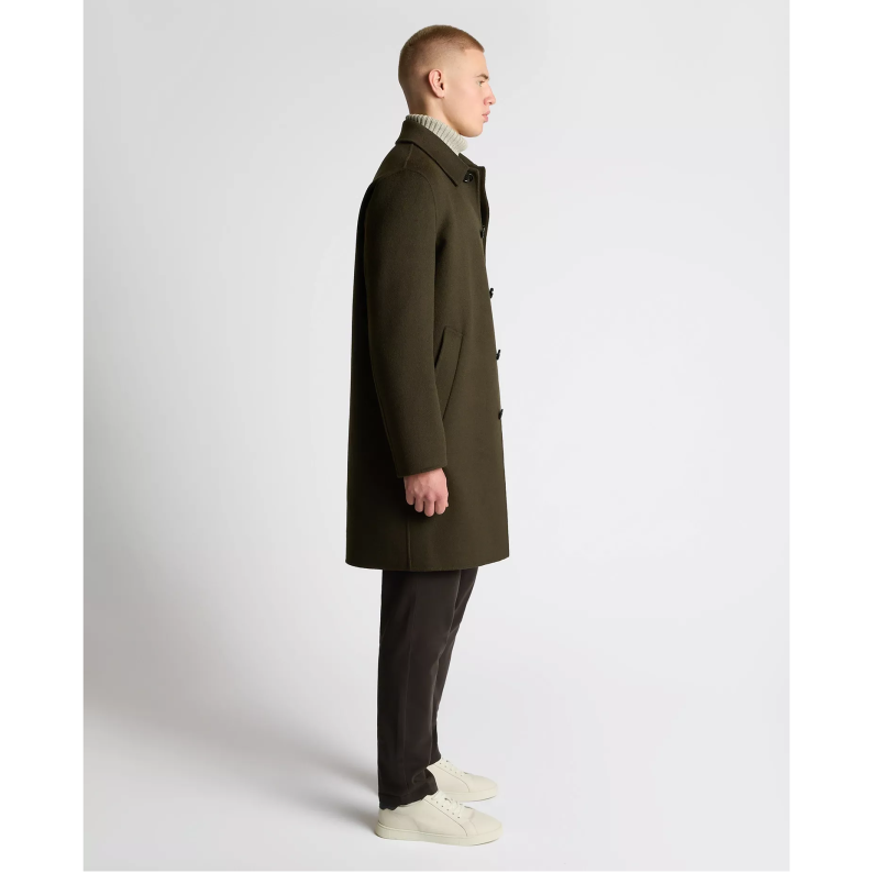 Man wearing a long dark coat on a white background