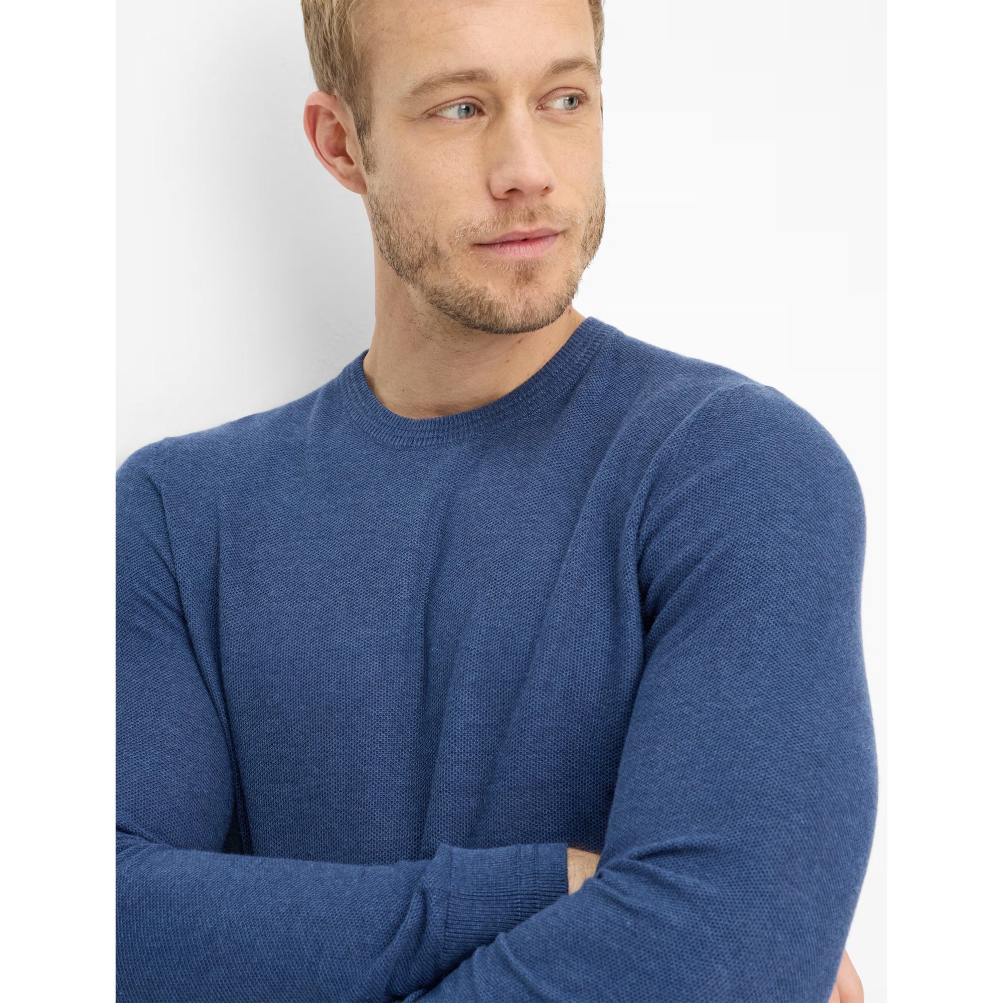 Man wearing a blue sweater against a white background