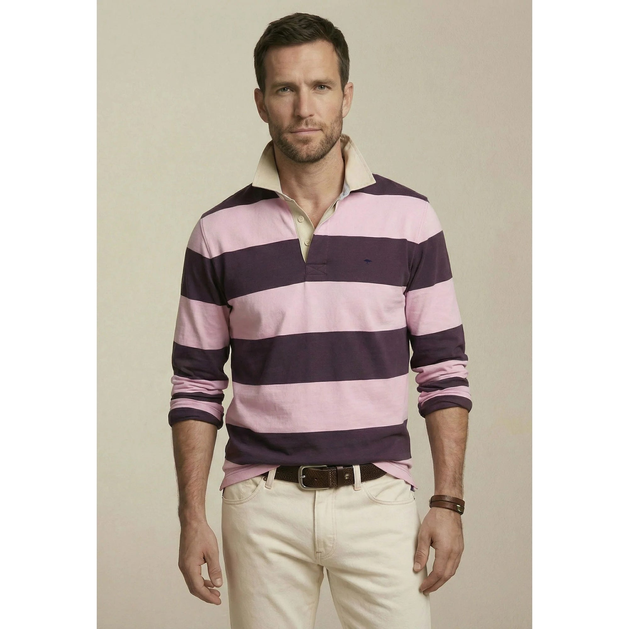 Man wearing a pink and purple striped shirt with beige pants on a plain background
