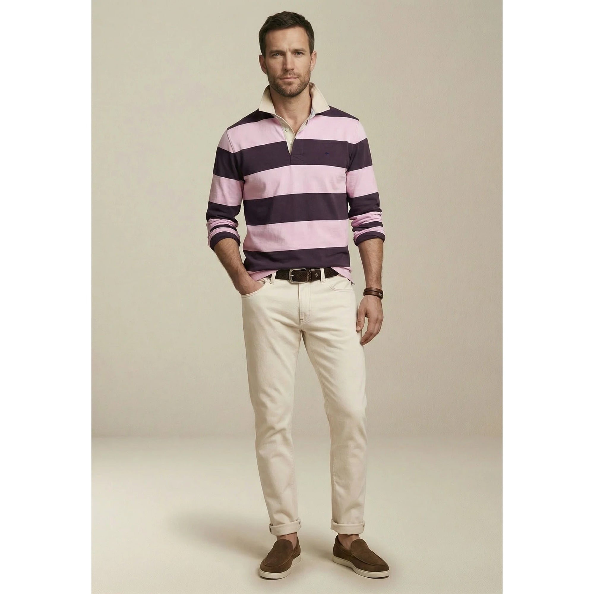 Man wearing a striped polo shirt and beige pants against a plain background