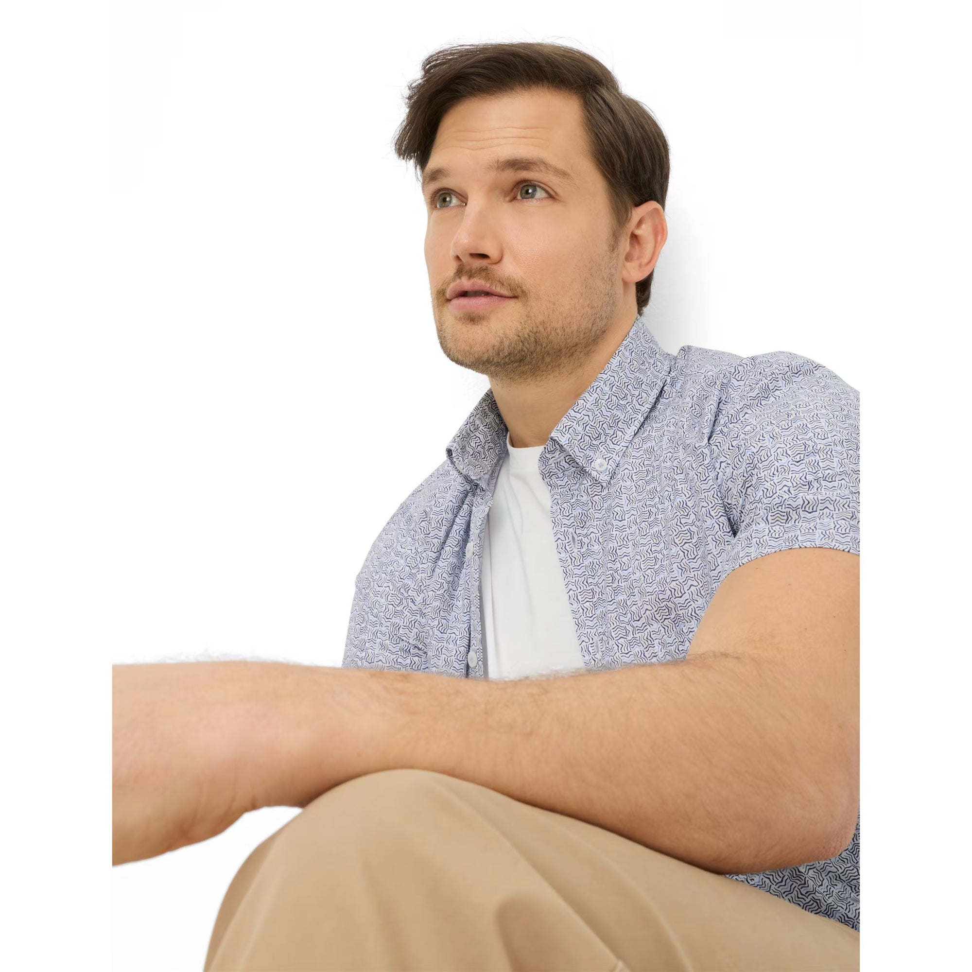 Man sitting with crossed legs on a white background