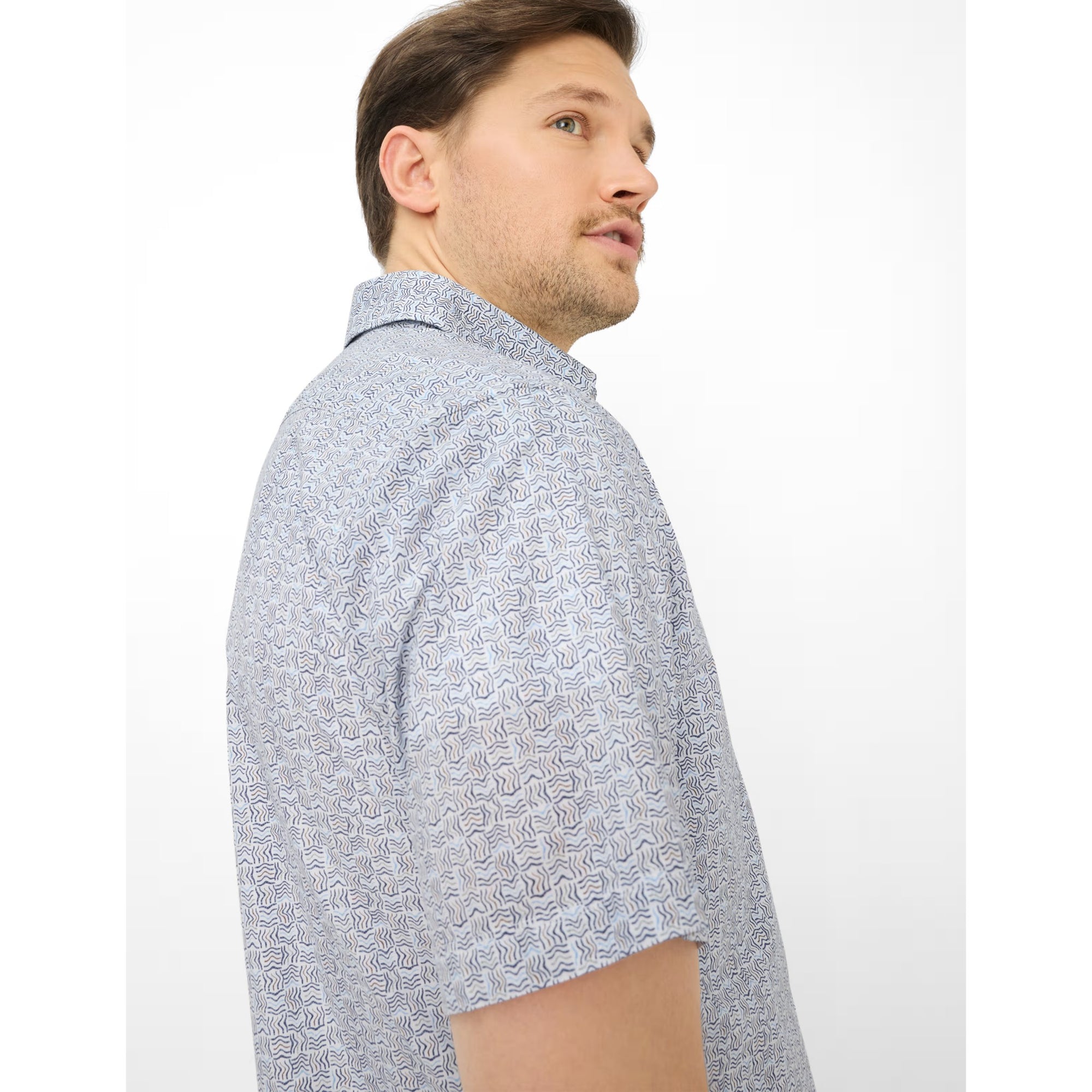 Man wearing a light blue patterned shirt on a white background