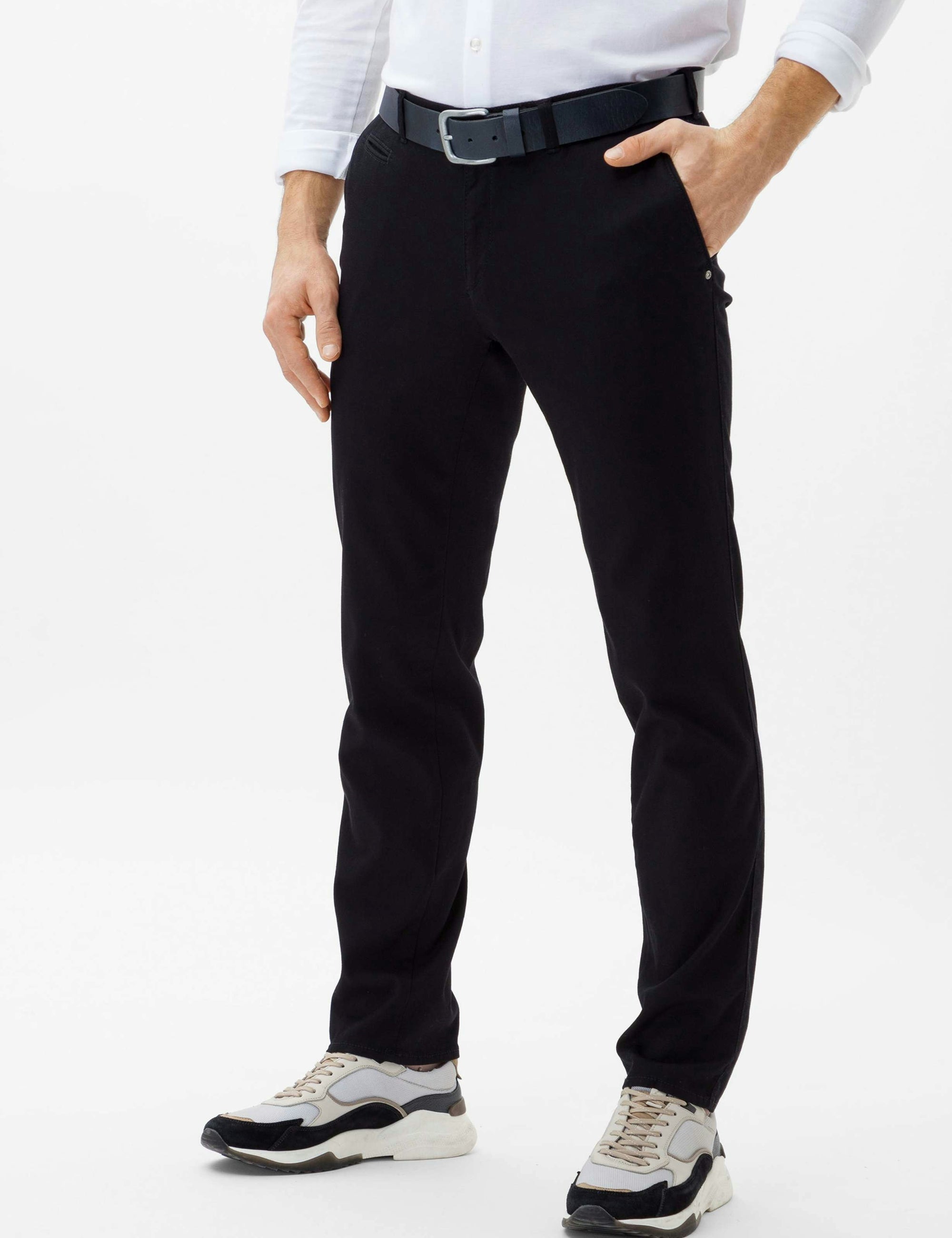 Person wearing black pants and a white shirt on a white background