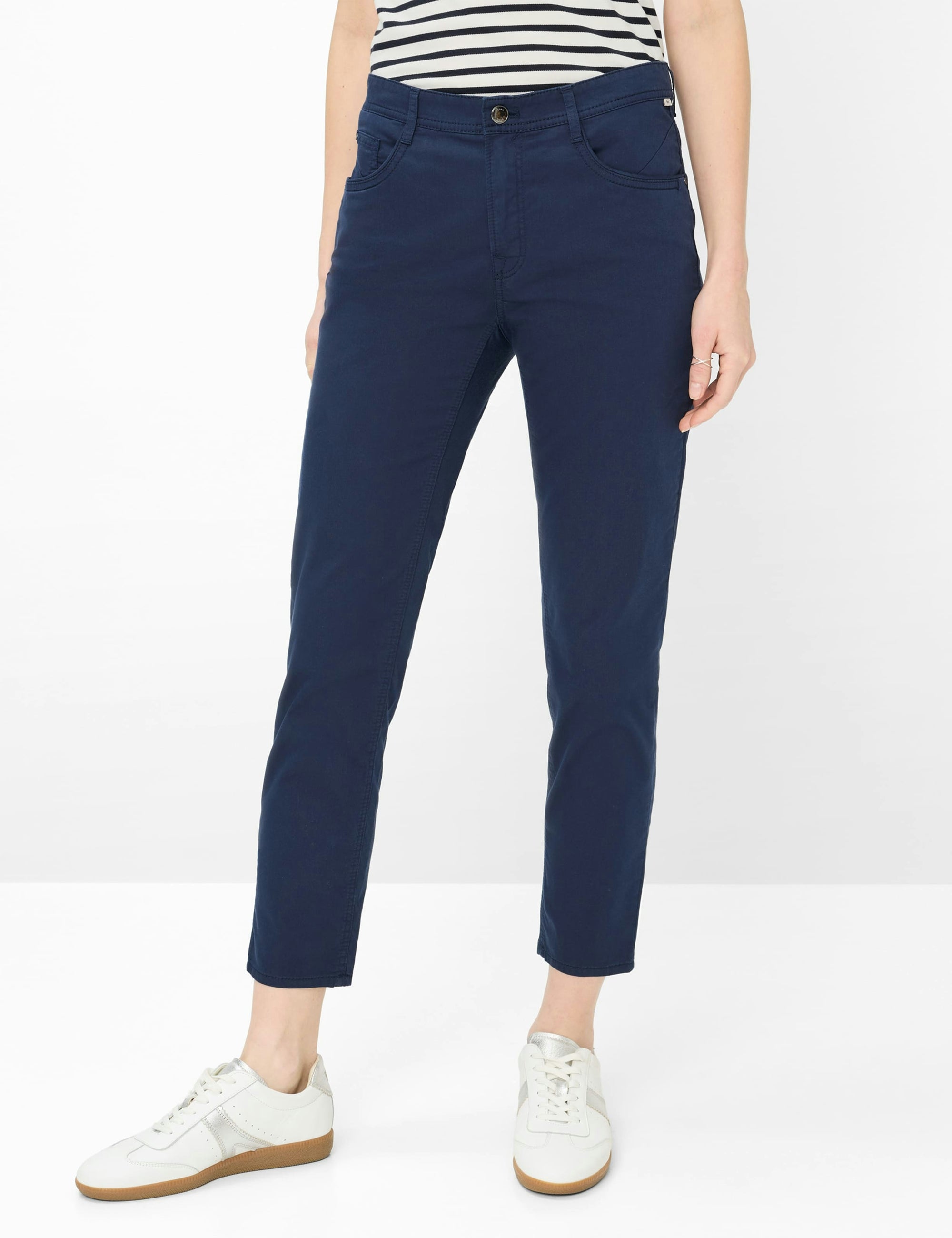 Person wearing navy blue pants with a white background