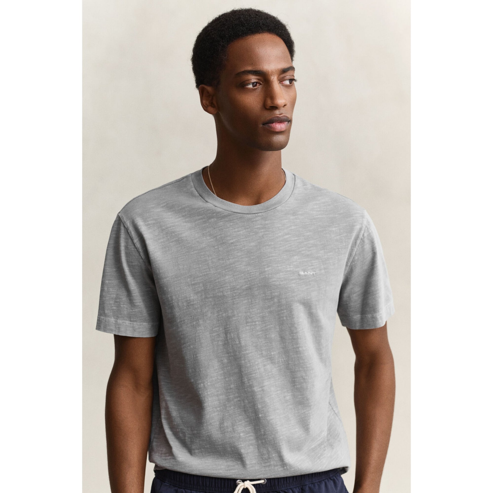 Man wearing a gray t-shirt against a plain background