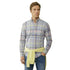 Man wearing a plaid shirt with a yellow tie against a beige background