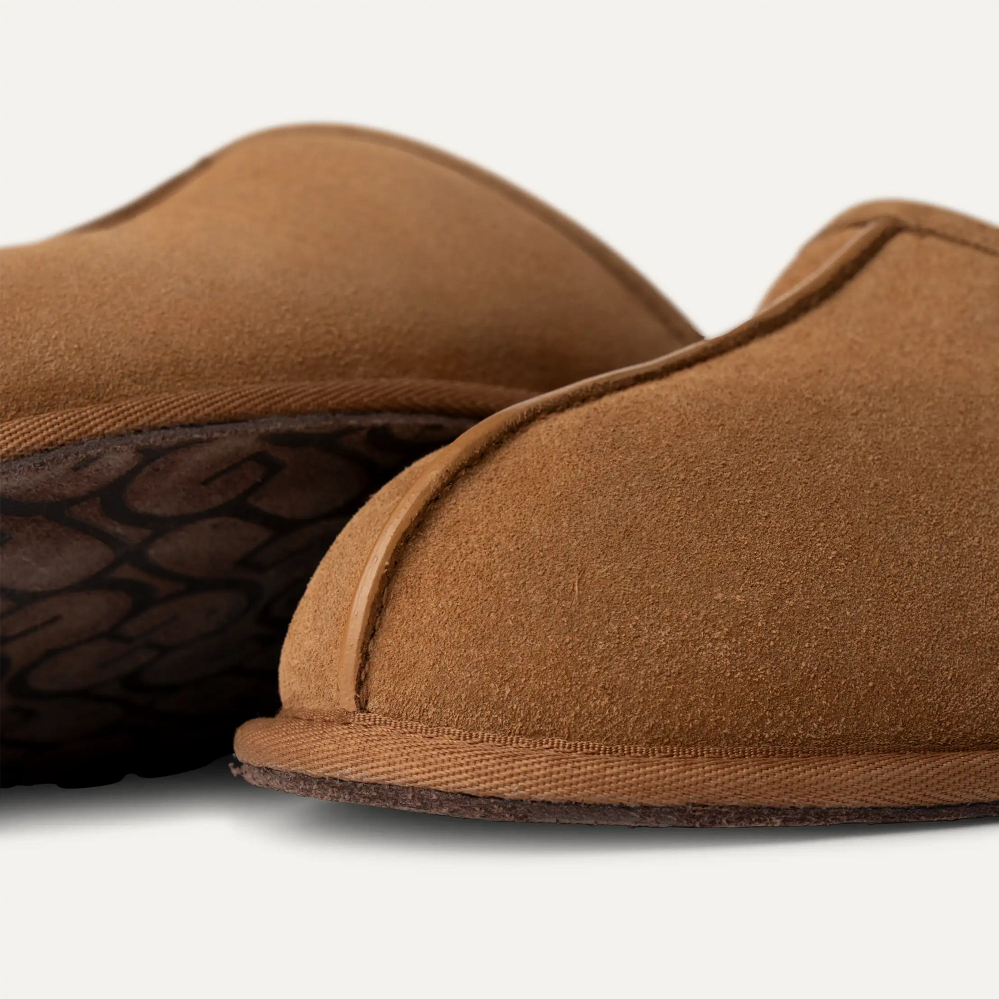 Pair of brown slippers on a light gray background